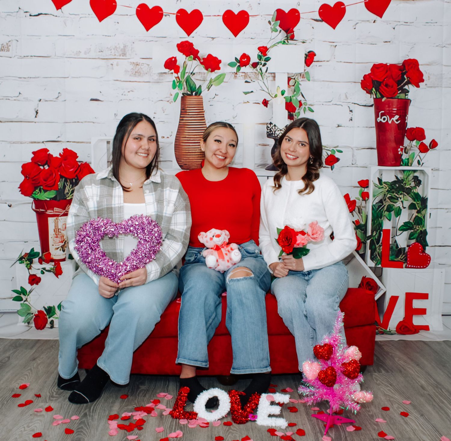 Valentine themed photo set with love signs and floral decorations.