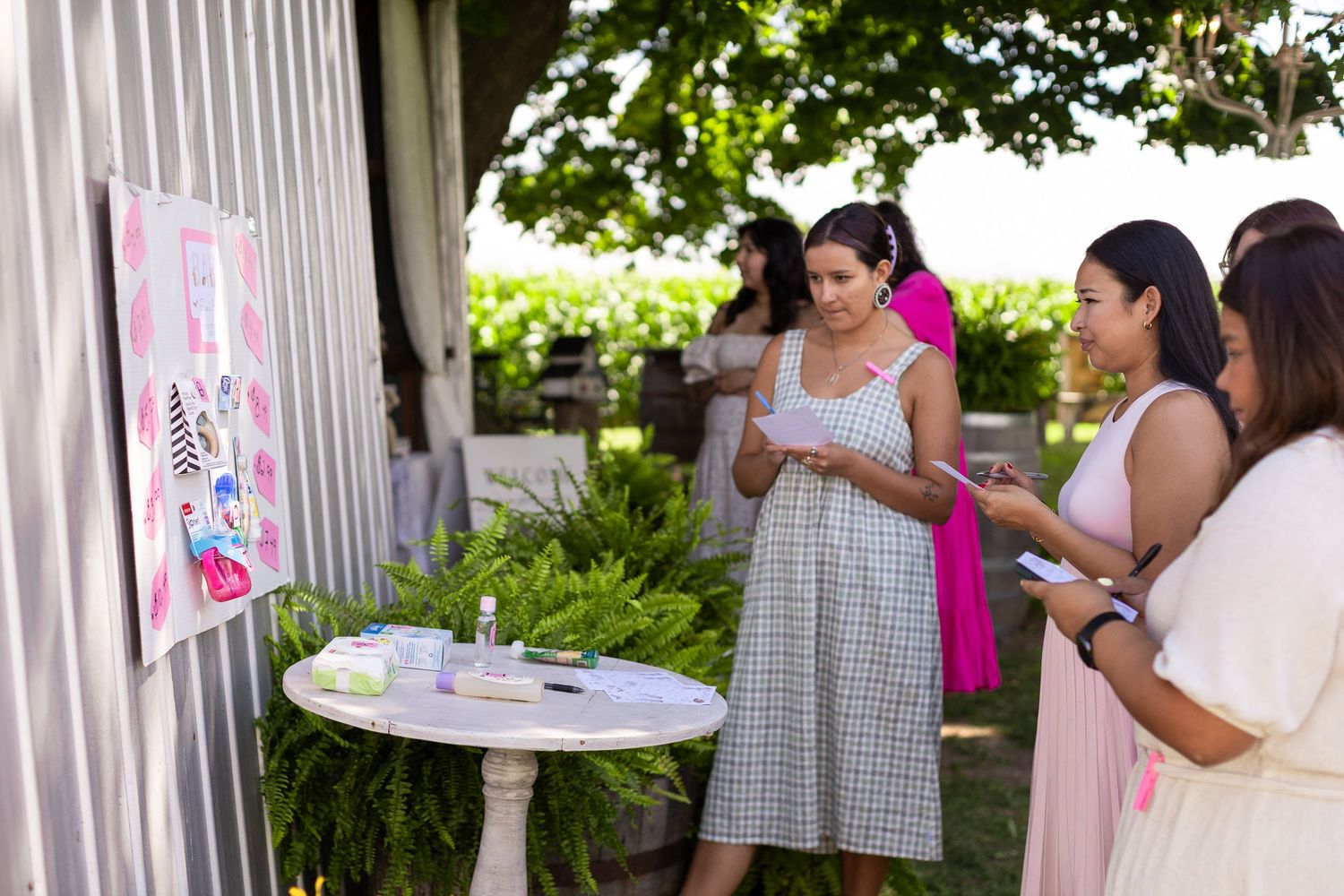 Outdoor party setup with white fencing and decorative pink accents.