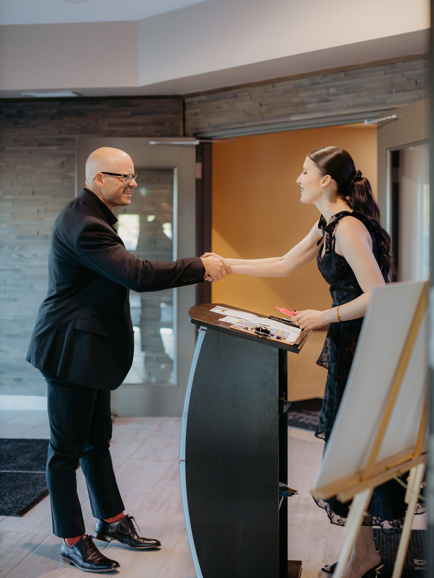 Two performers engage in an expressive dance sequence in a modern indoor setting.