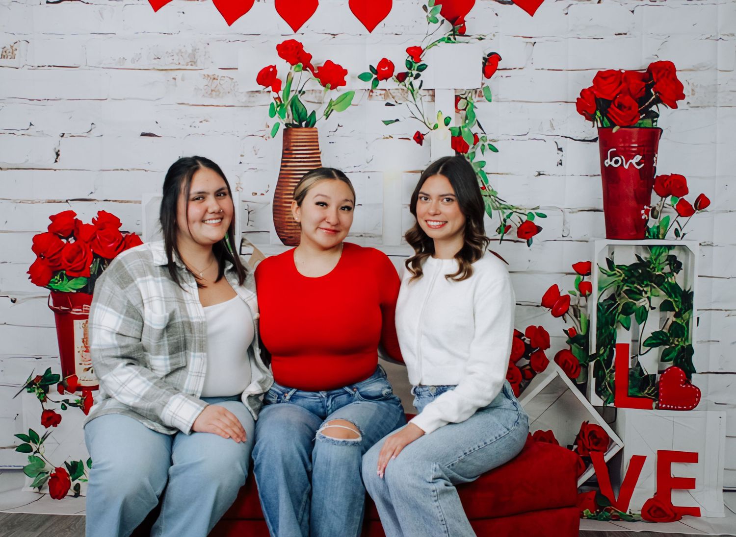 Family valentine photo session with red and white decorative elements.