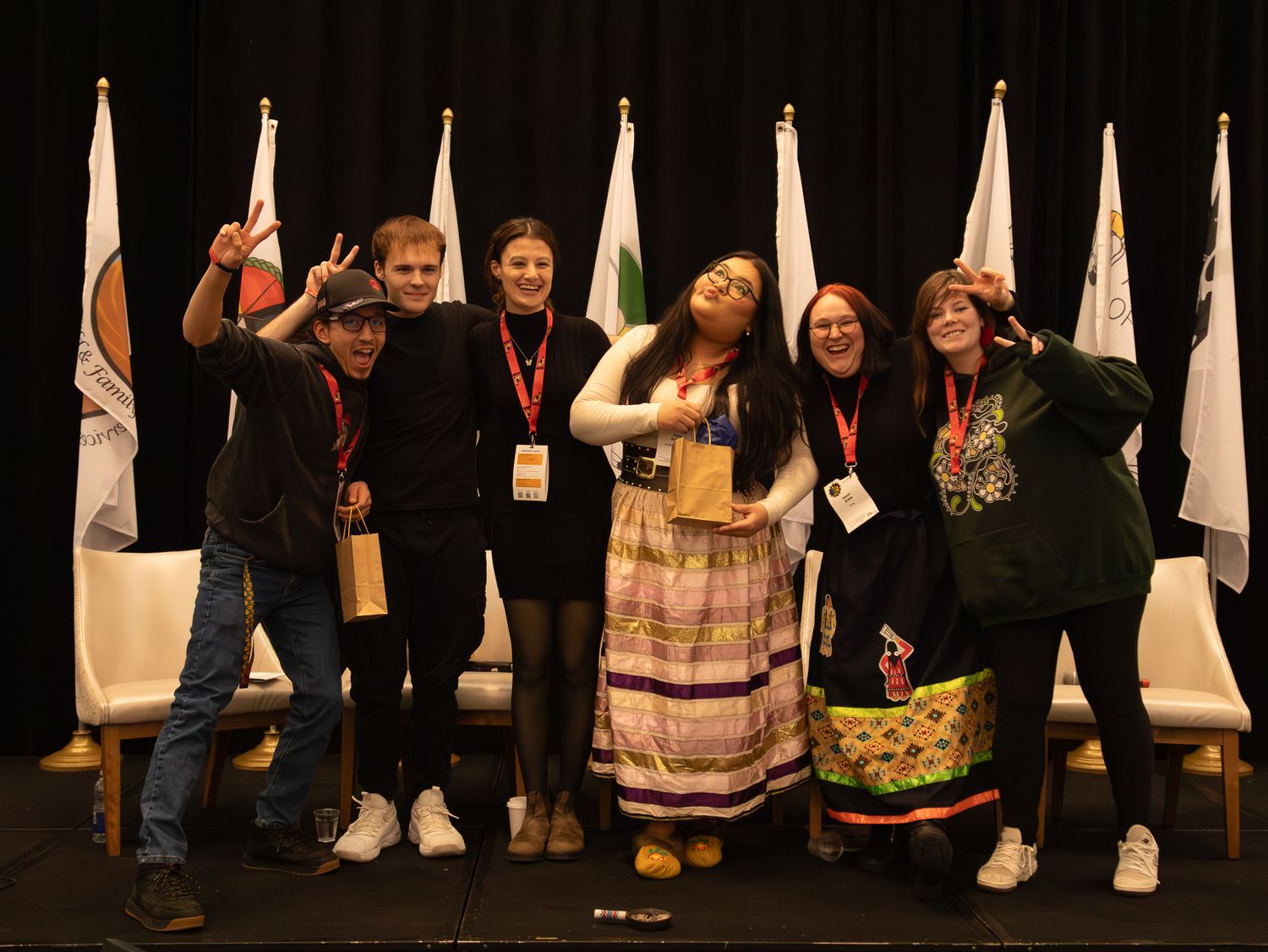 Attendees standing in line with white banners displayed at indoor event.