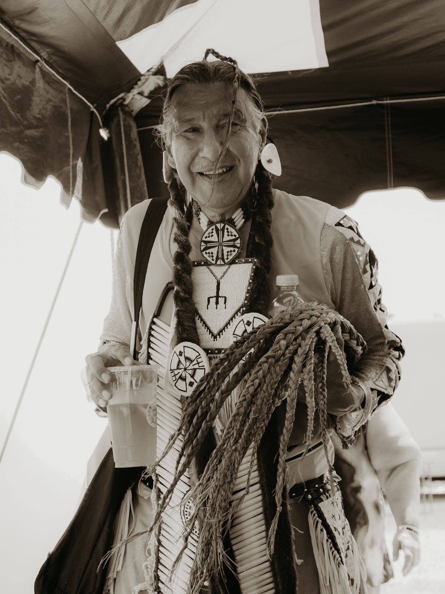 Traditional Native American dancer wearing ornate regalia with feathers and beadwork.