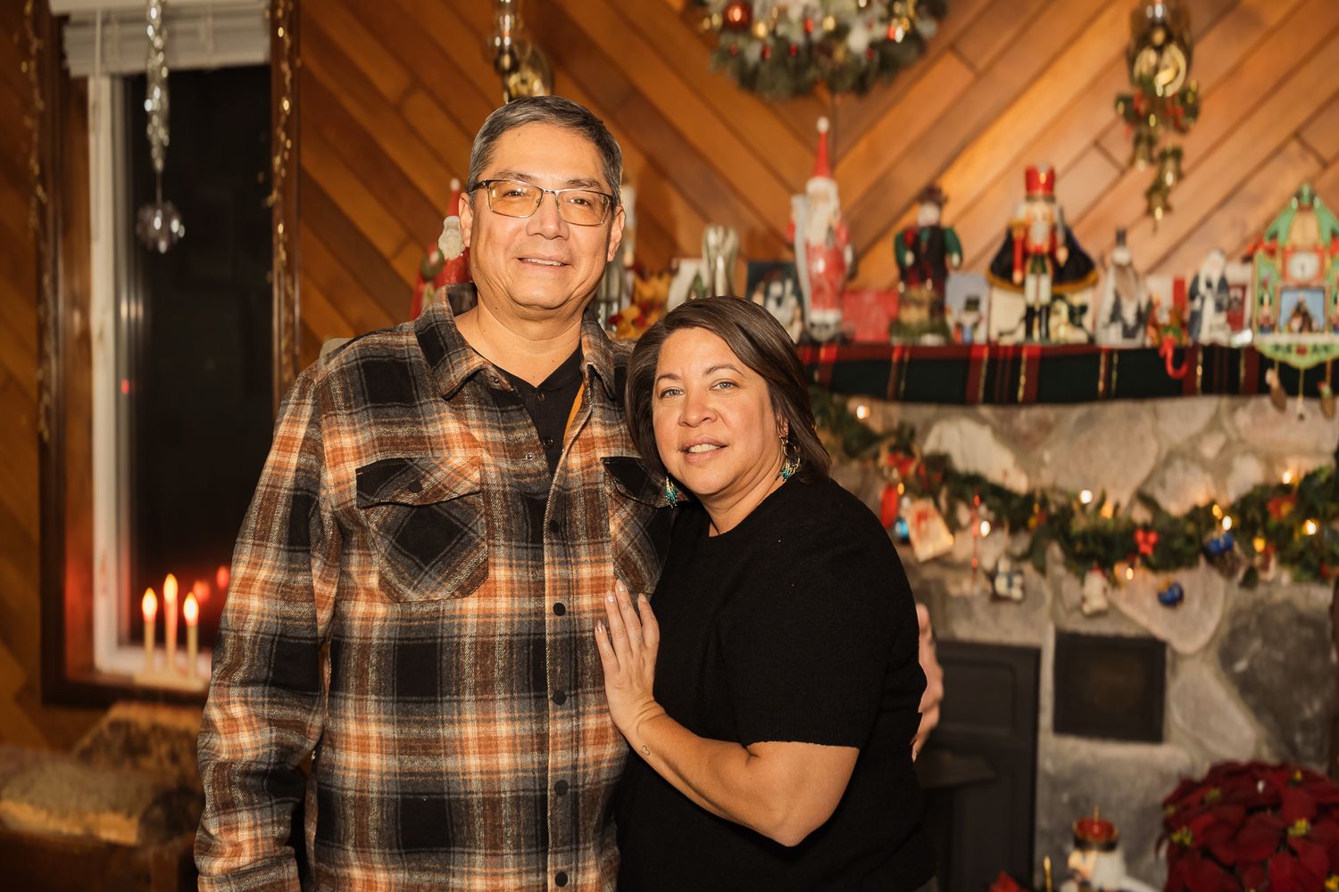 Holiday photo with wood paneled walls, Christmas tree, and festive decorations.