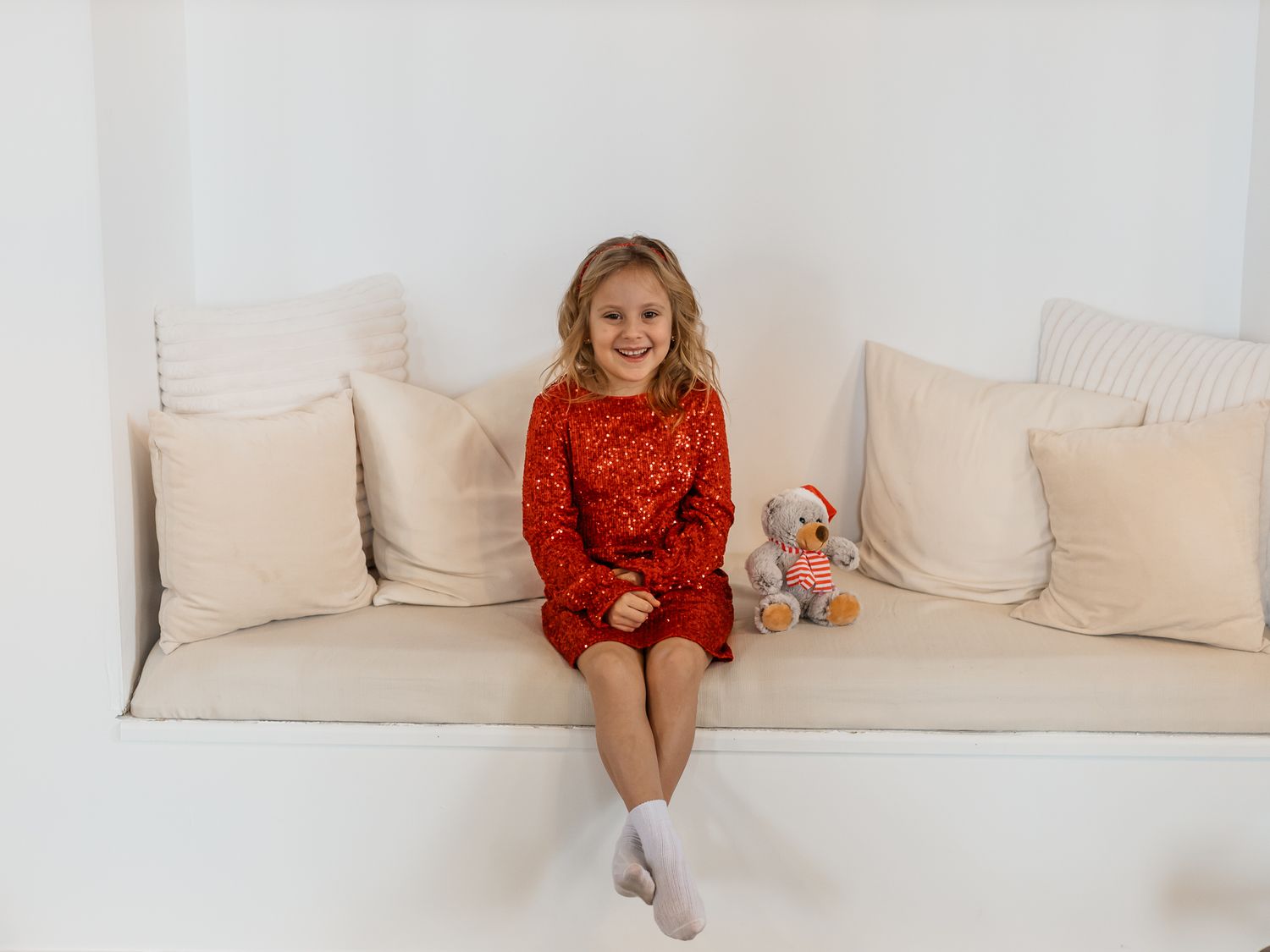Candid moments on white couch during holiday family photo session.