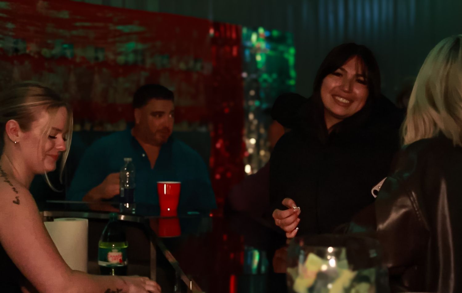 Festive holiday party scene with red and green lighting creating atmospheric ambiance.