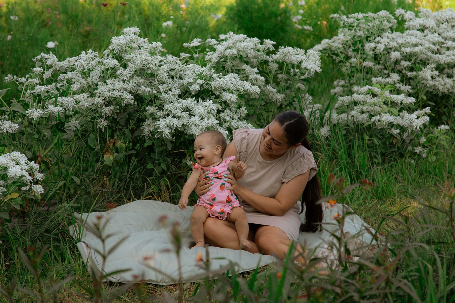 Casual family photography session in a meadow with white wildflowers.