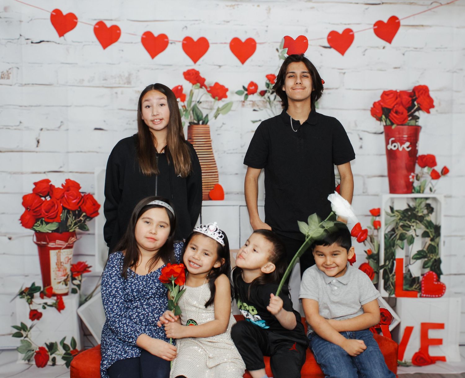 Family group photo with Valentine's day themed decorations and red roses.