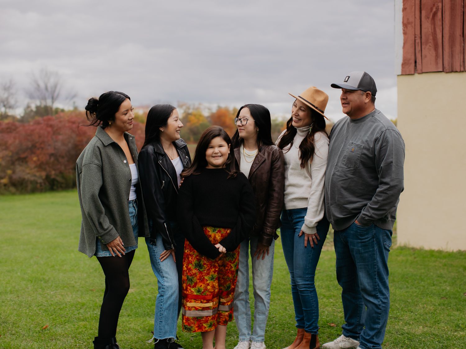 Extended family members gather for group photos outside on an autumn afternoon.