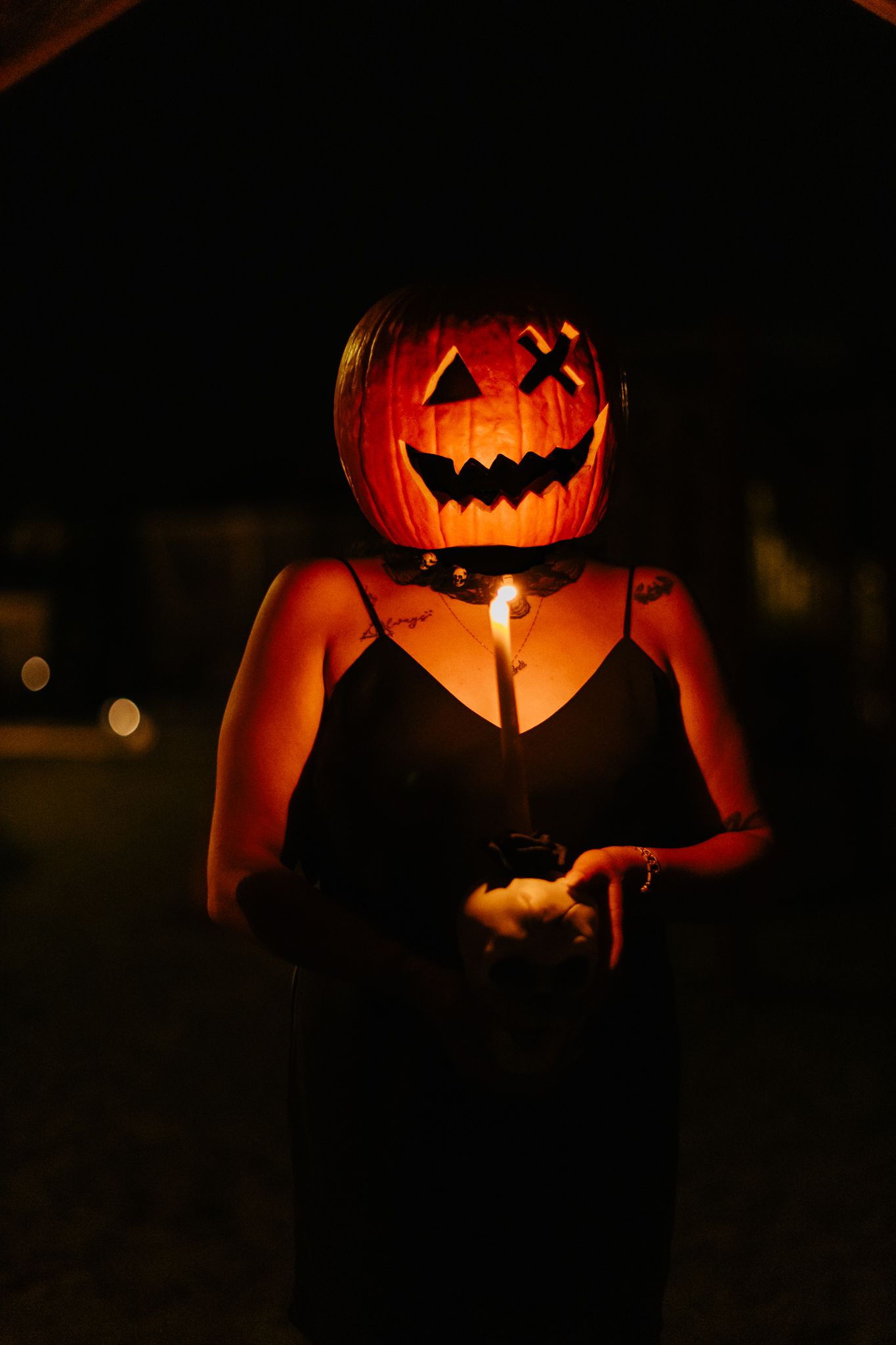 Glowing jack-o'-lantern held in darkness creating spooky Halloween ambiance.