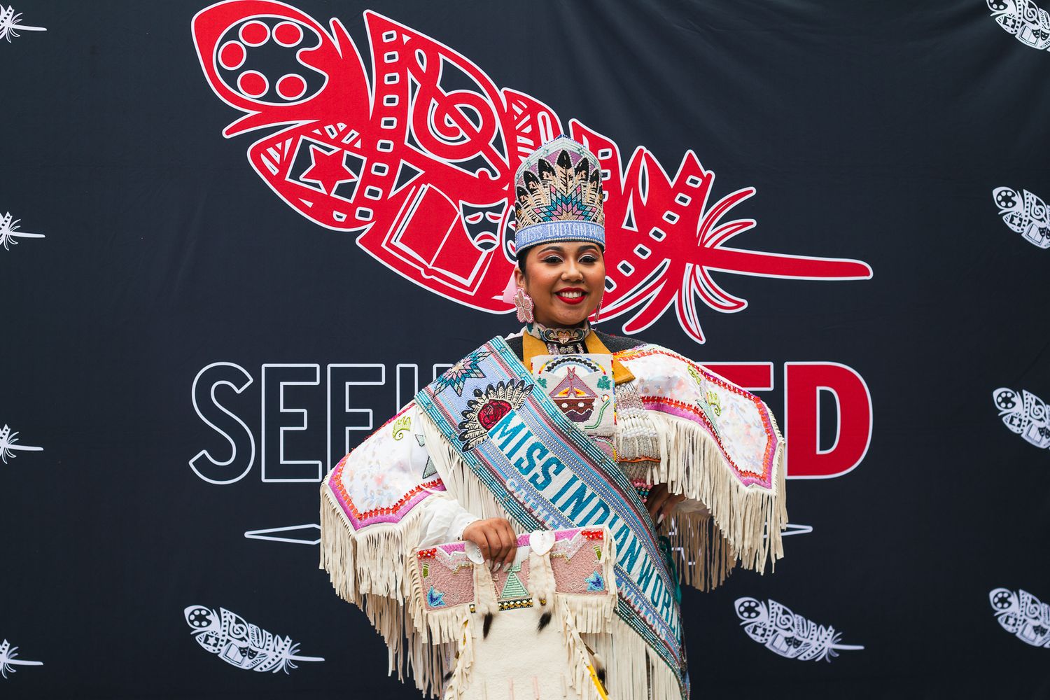 Performance scene with red logo backdrop and traditional costume elements.