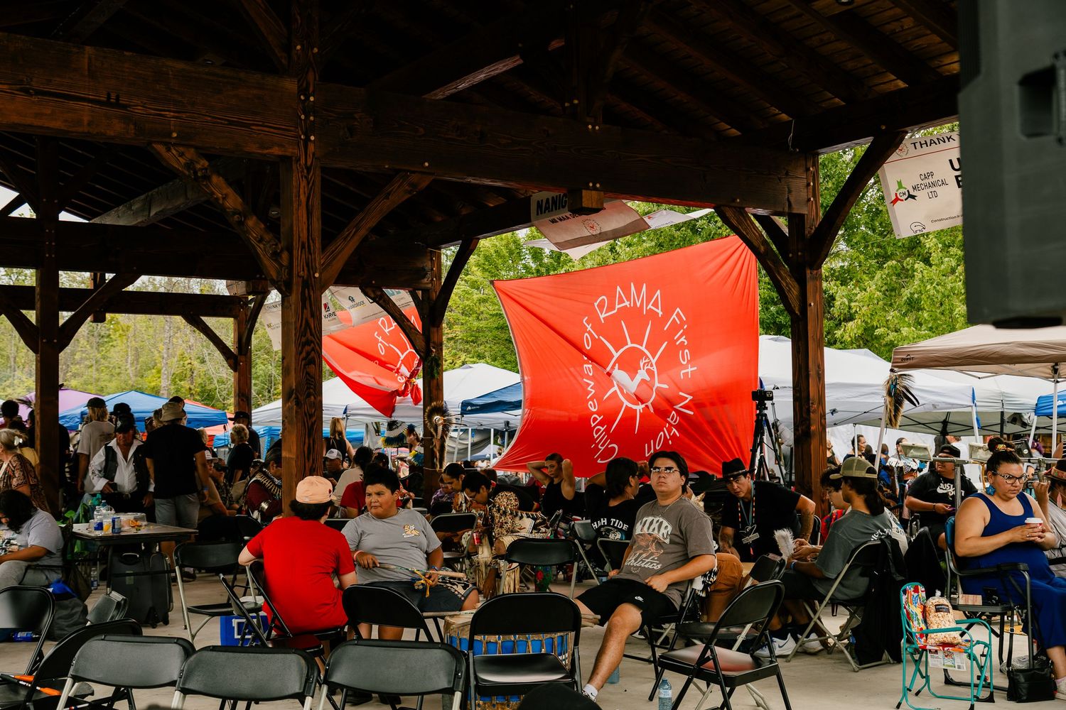Covered pavilion with people gathered for a community event.