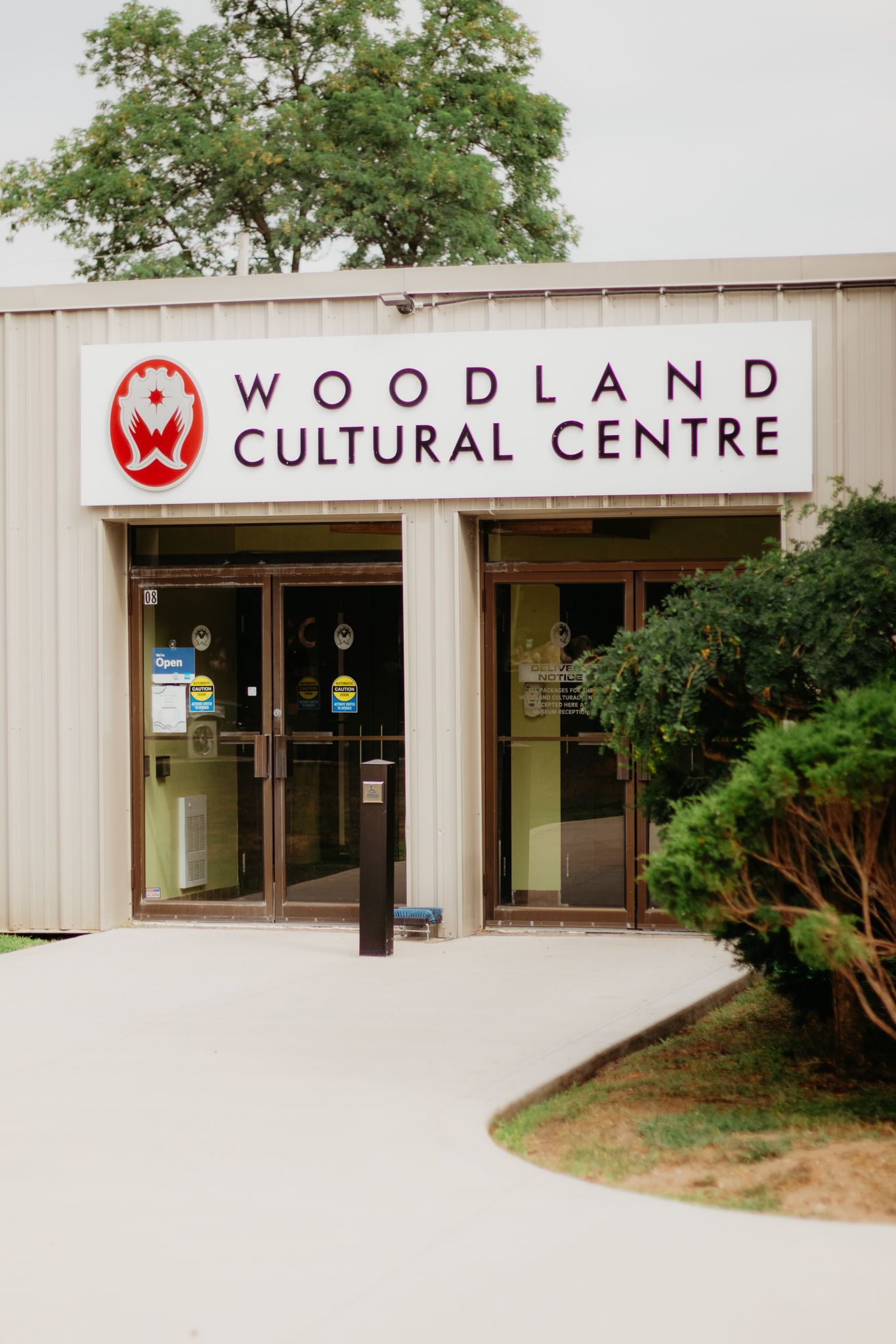 Exterior view of the Woodland Cultural Centre building with signage and trees.