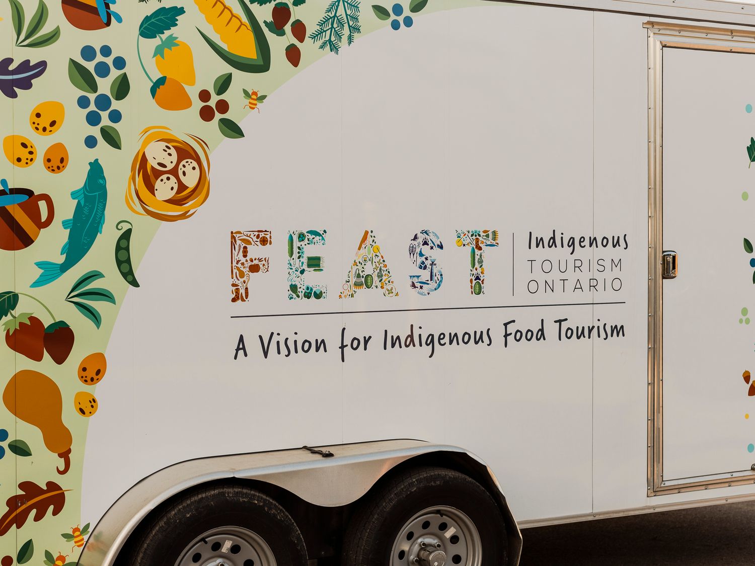 FEAST Indigenous Tourism Ontario food trailer promoting a vision for Indigenous food tourism with colorful artwork.