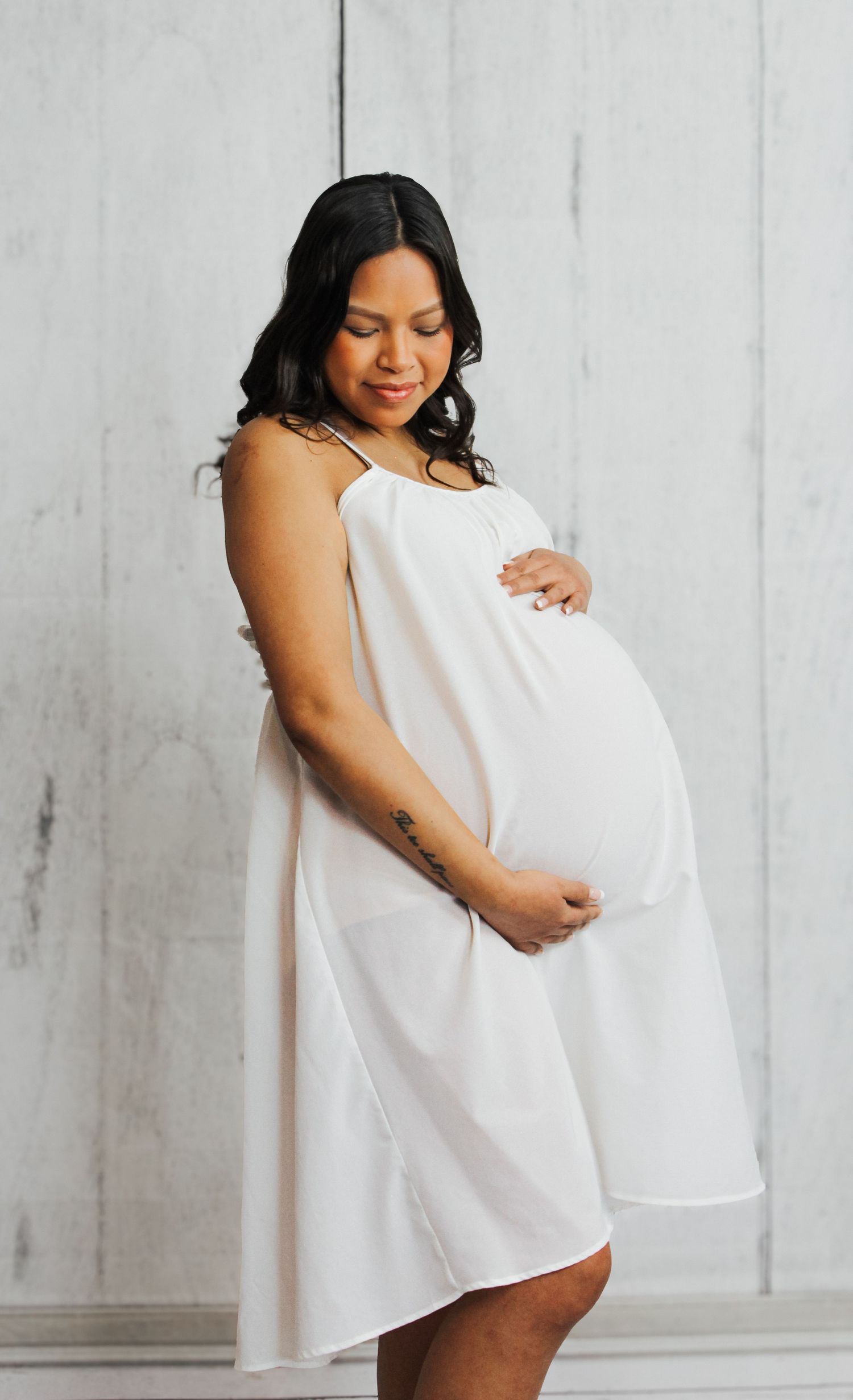 Intimate maternity photography session with soft white fabric and natural poses.