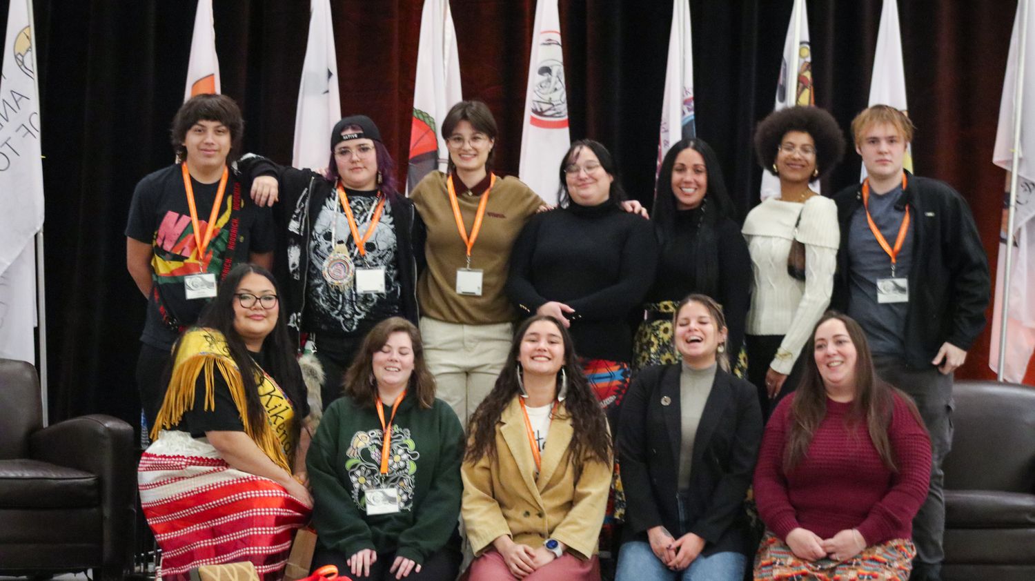 Group photo setup in a conference venue with traditional indigenous elements visible.
