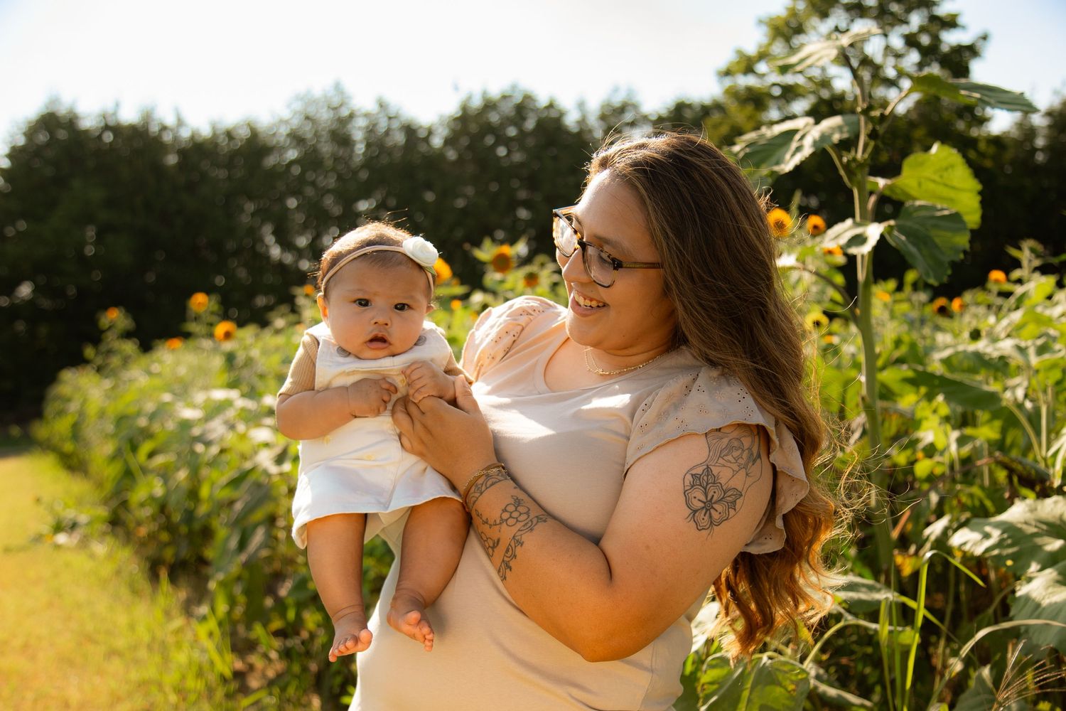 Yellow wildflowers and sunlit greenery create a natural backdrop for a summer portrait session.