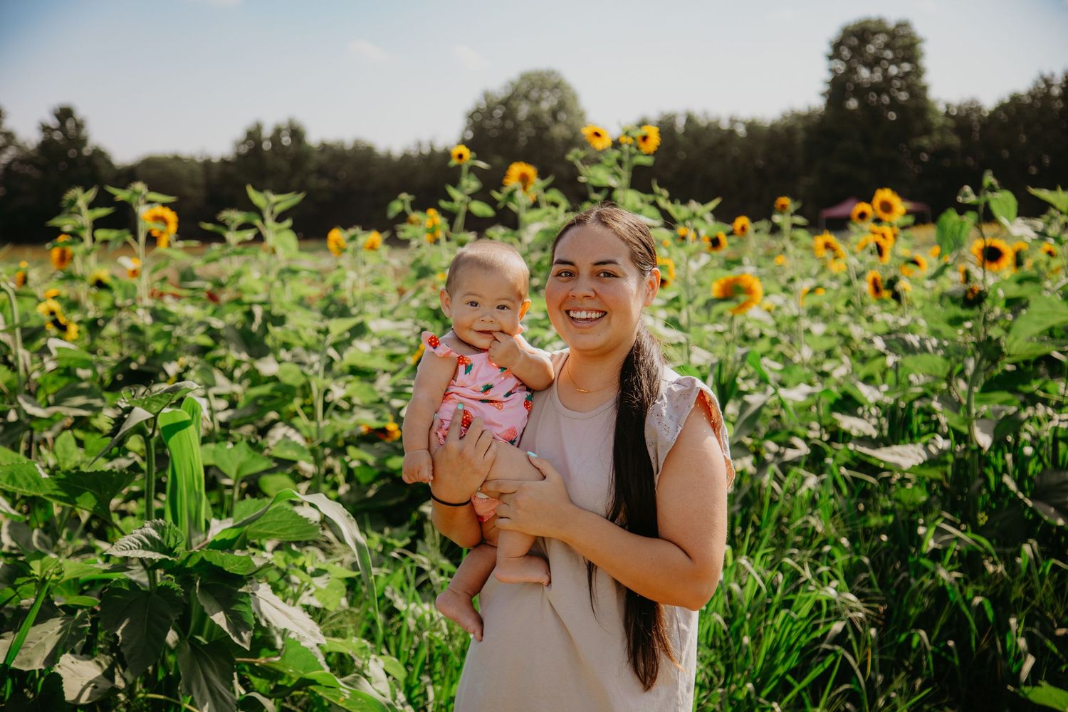 A cheerful moment captured in a sunflower field on a sunny afternoon.