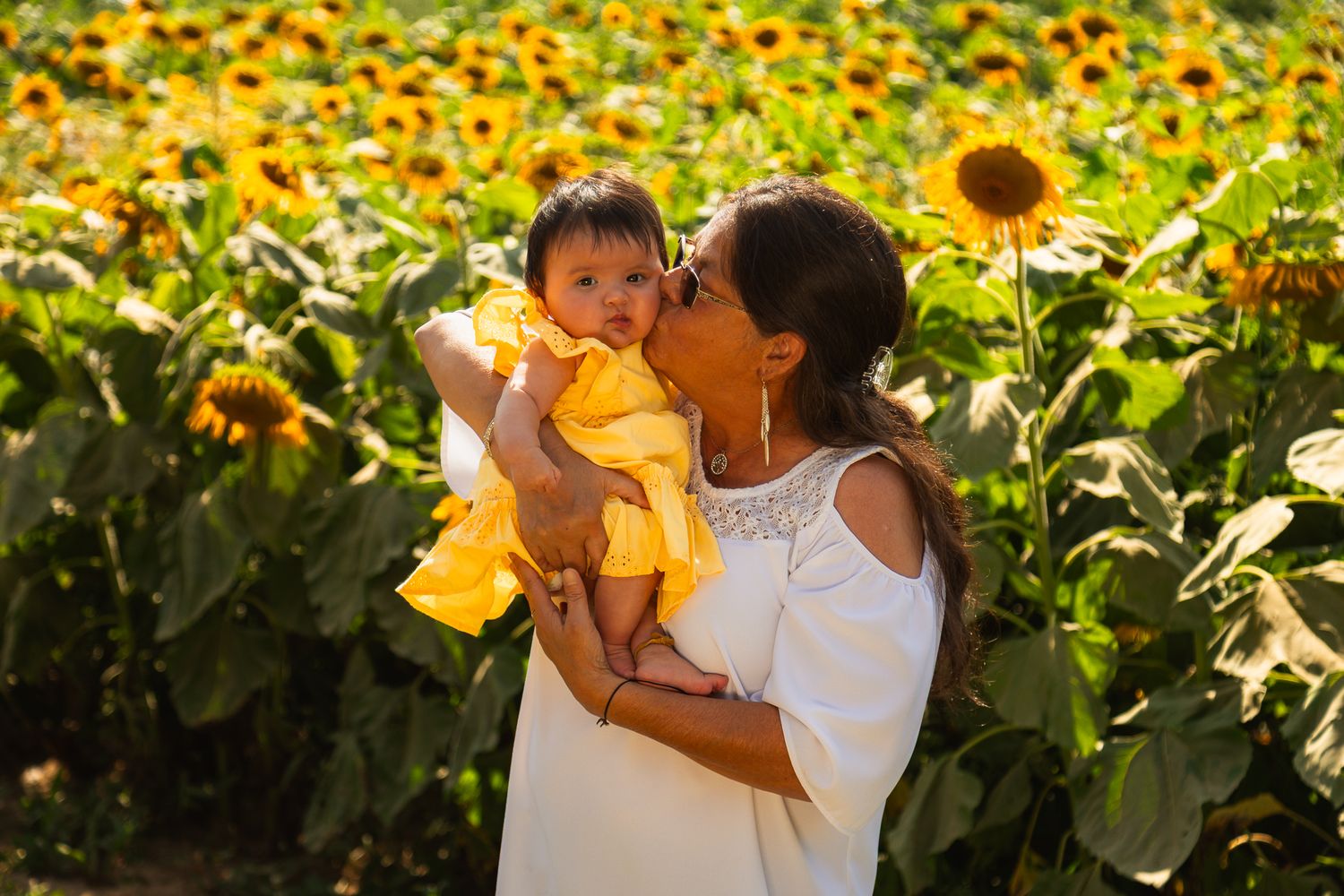 A family moment captured in a vibrant field of blooming sunflowers.