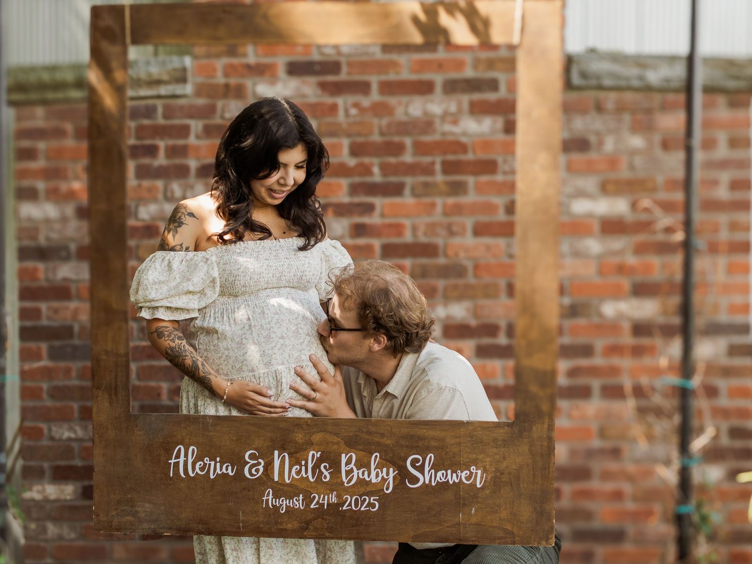 Baby shower celebration with decorative signage and exposed brick wall interior.