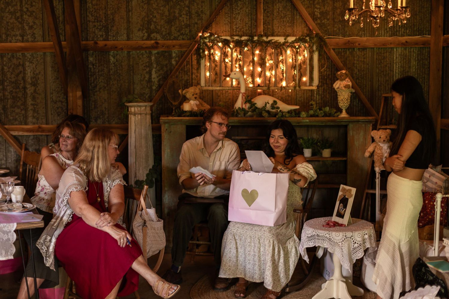 Rustic indoor venue with chandeliers and decorated tables for a special celebration.