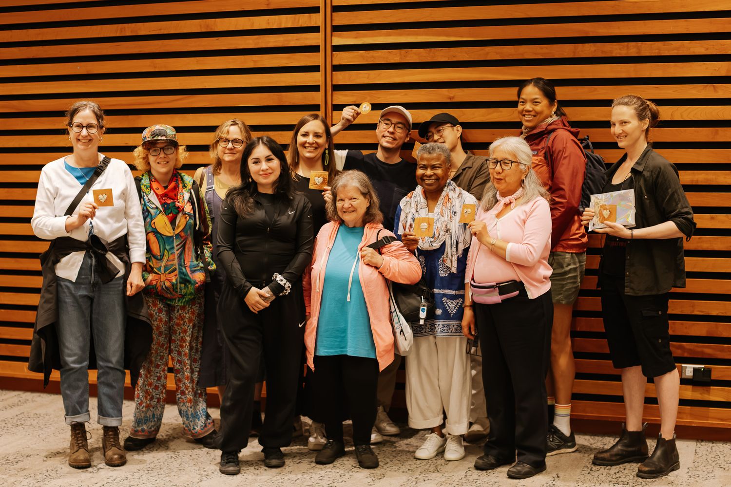 Diverse group of women posing together indoors, smiling and holding drinks at a social gathering event.