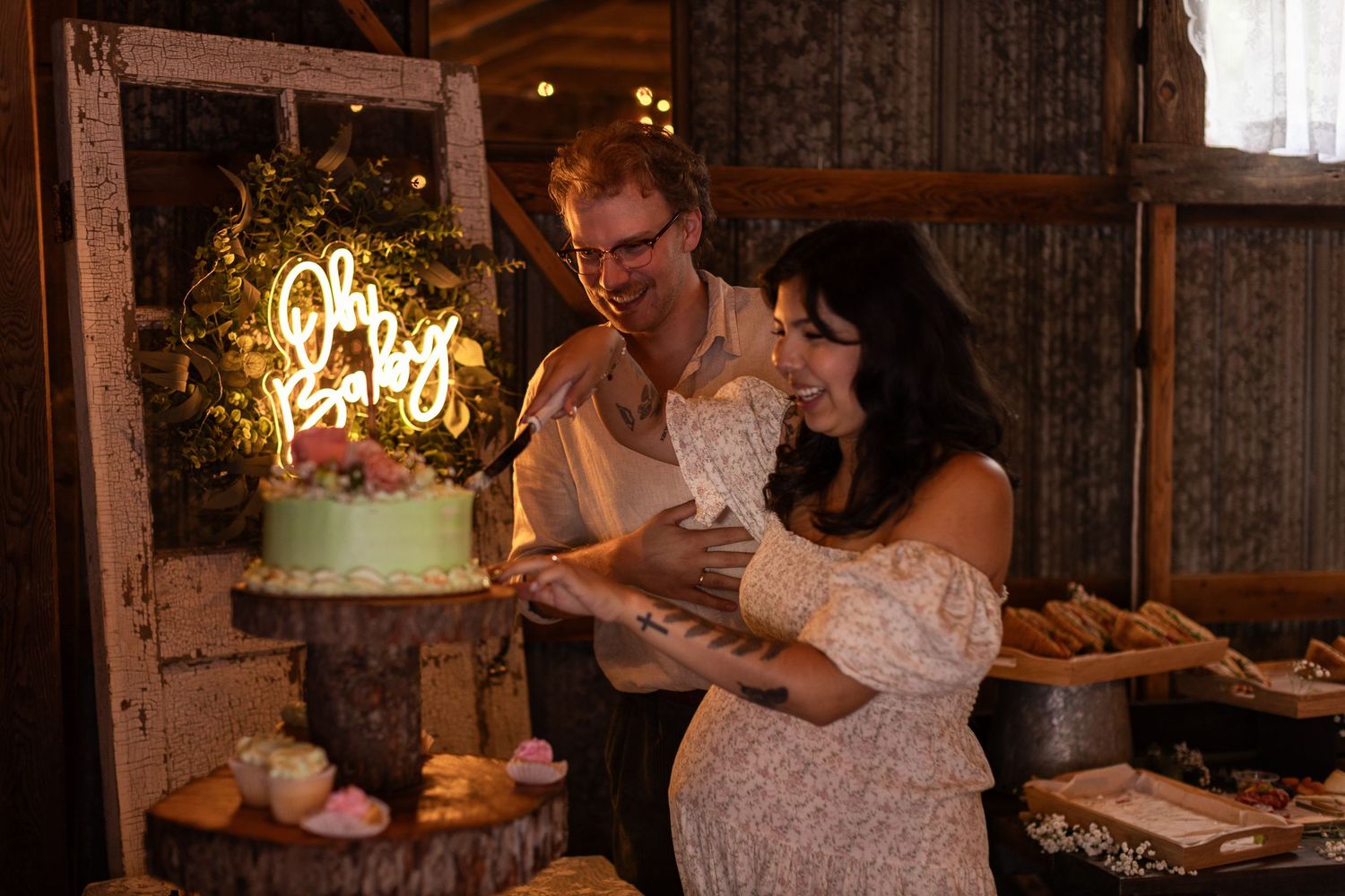 Guests gather around a dessert table at an elegant wedding reception with candlelight ambiance.