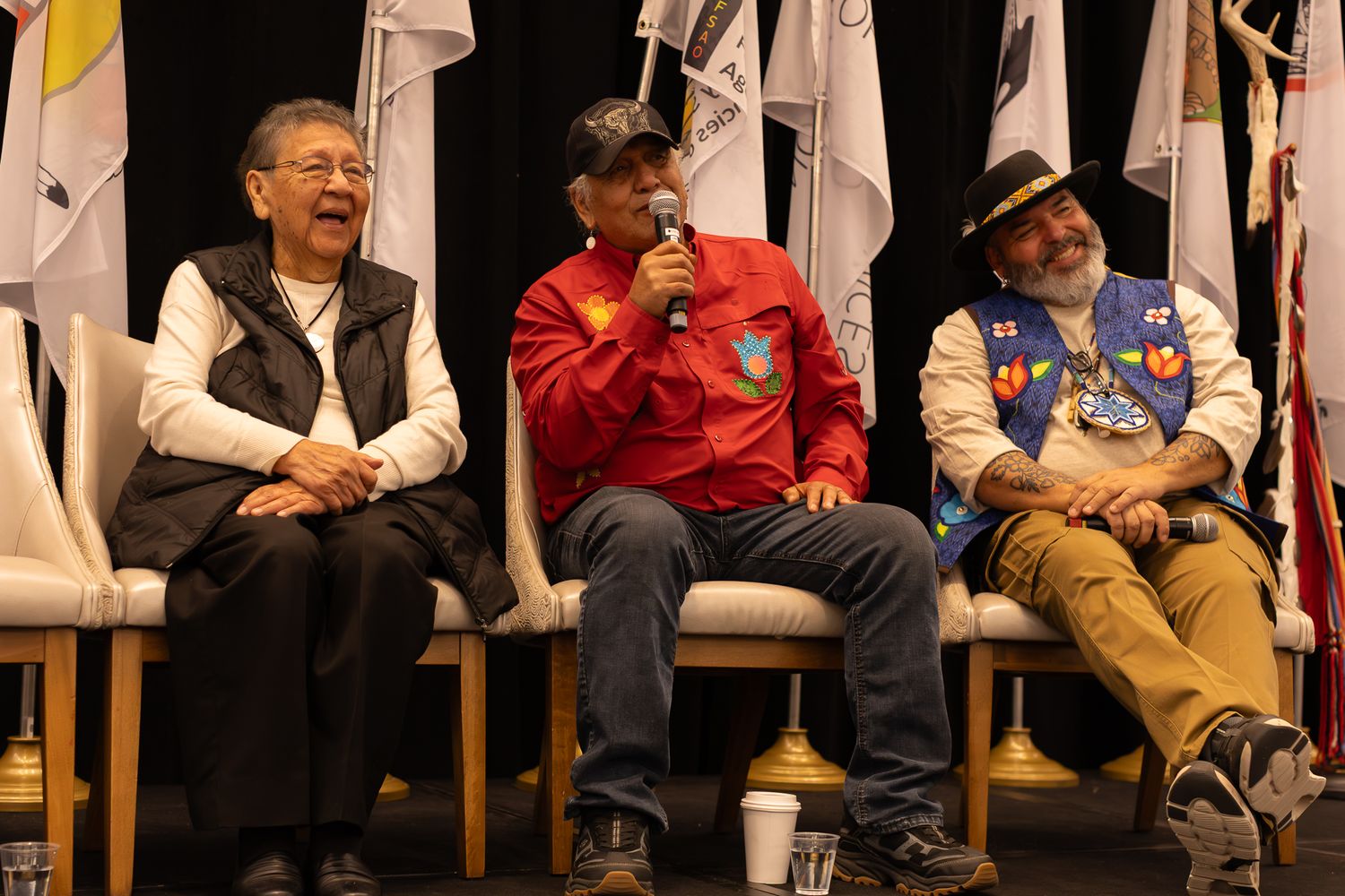 A group sits in chairs during what appears to be a panel discussion or presentation event.