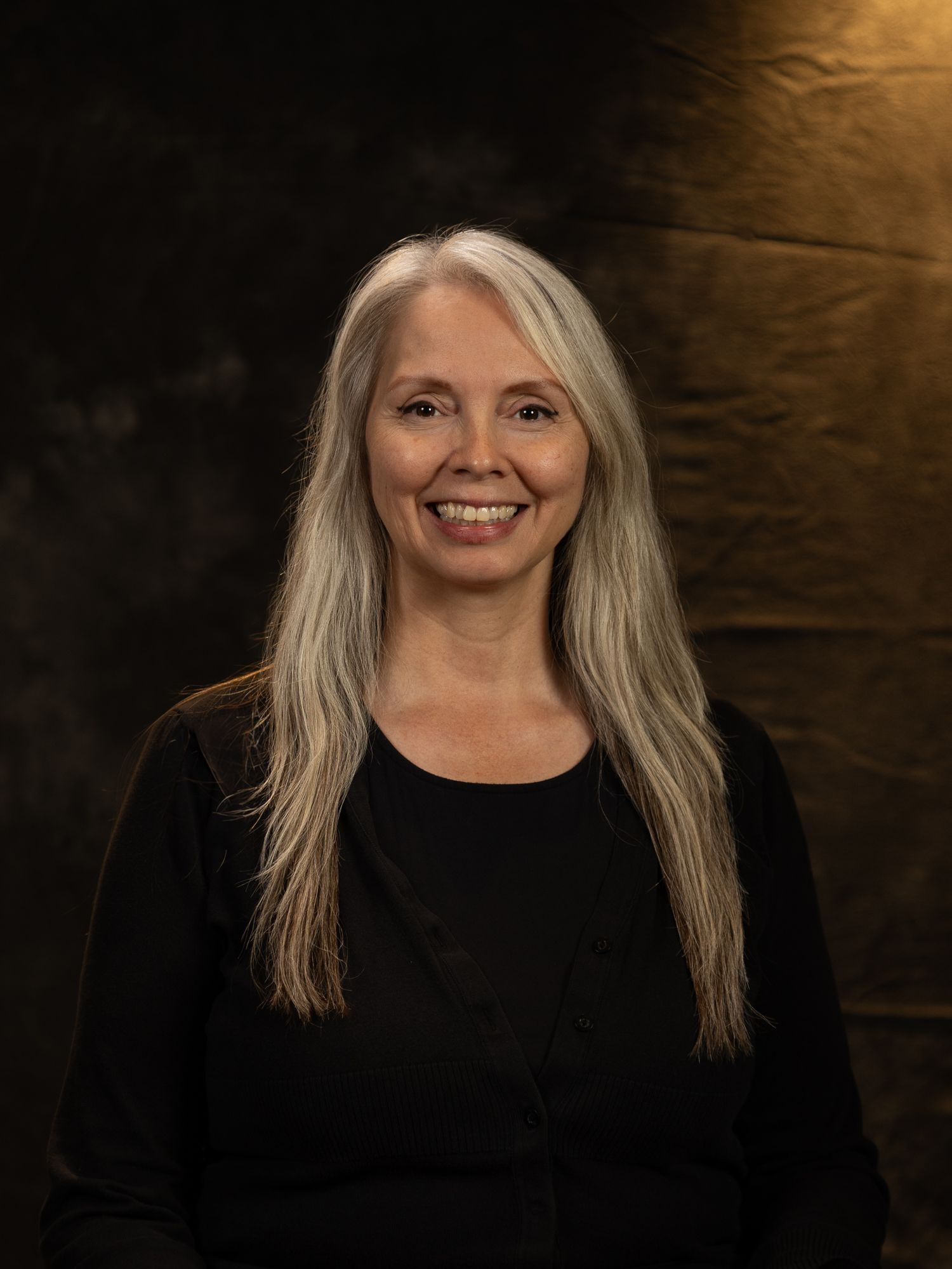 Multiple poses of someone with blonde hair wearing black against a dark textured background.