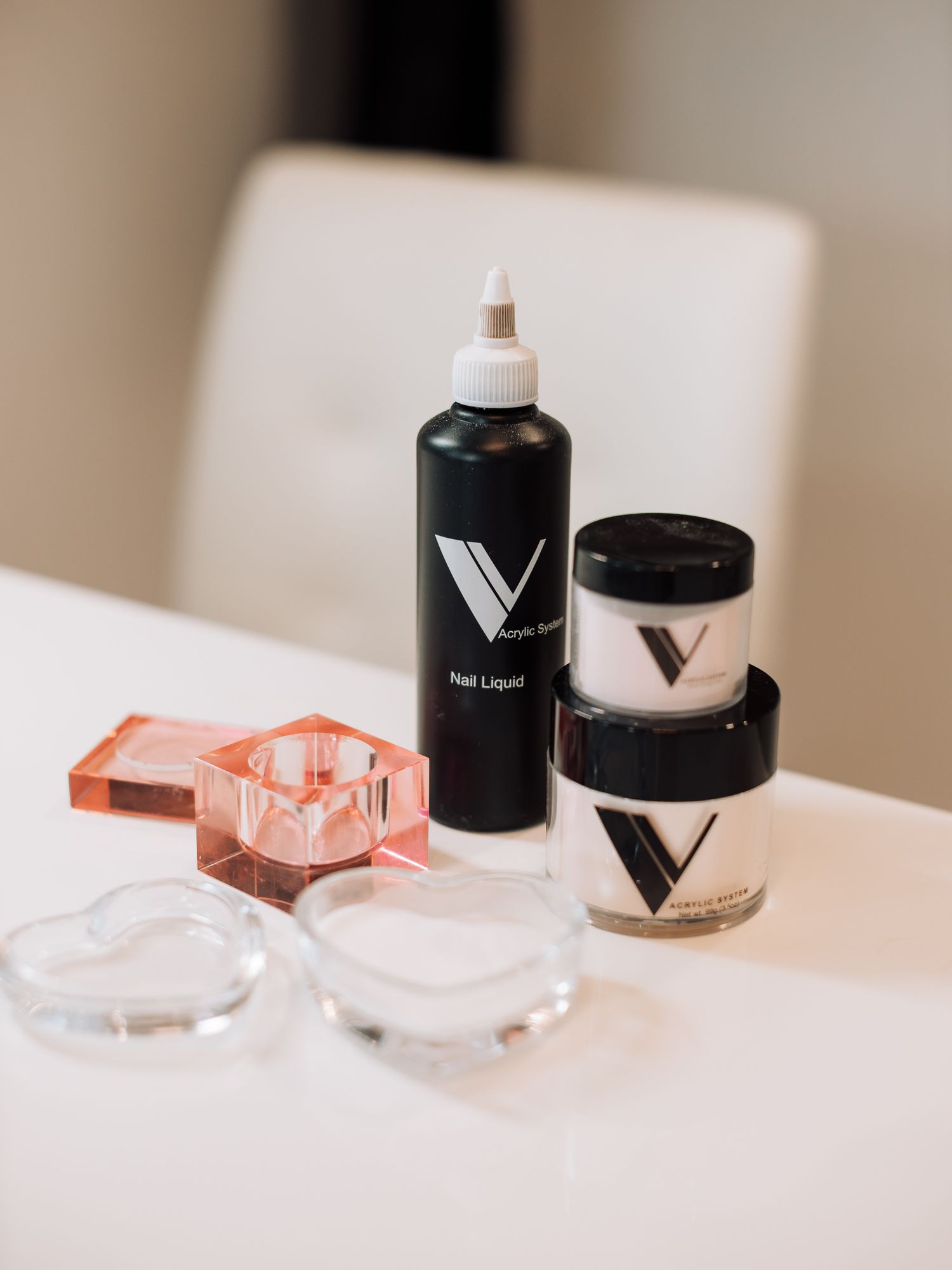 Nail care products and clear containers arranged on a white surface.