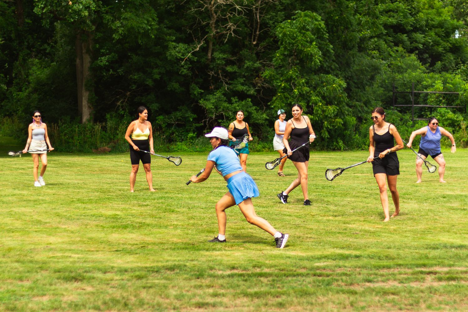 Group playing active games and running on a sunny grassy field.