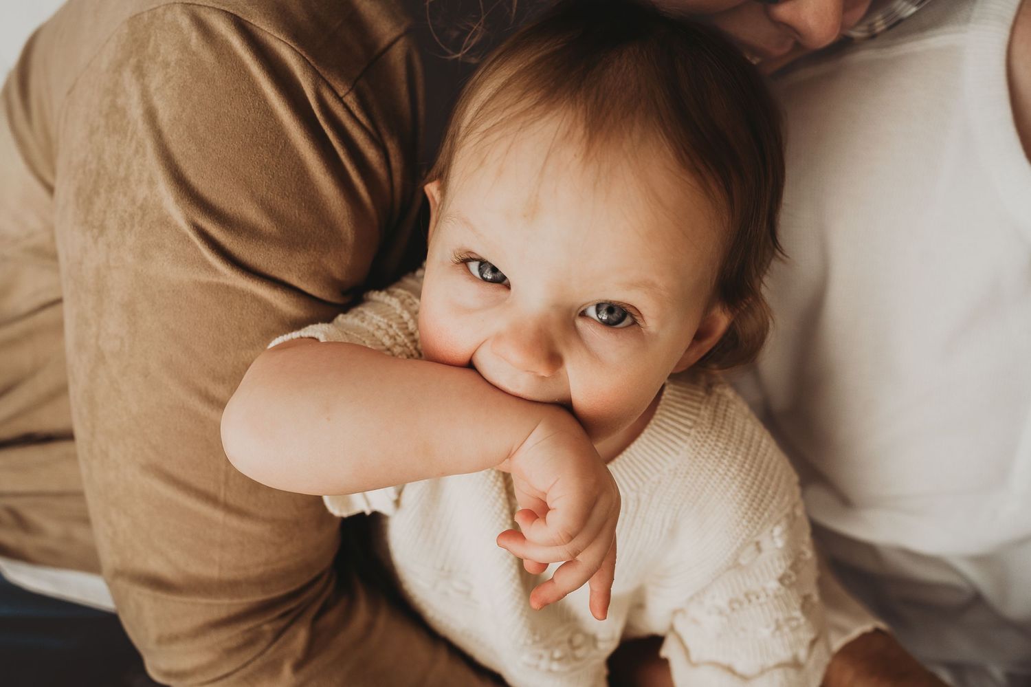 Intimate close-up shots on beige background showing tender moments.