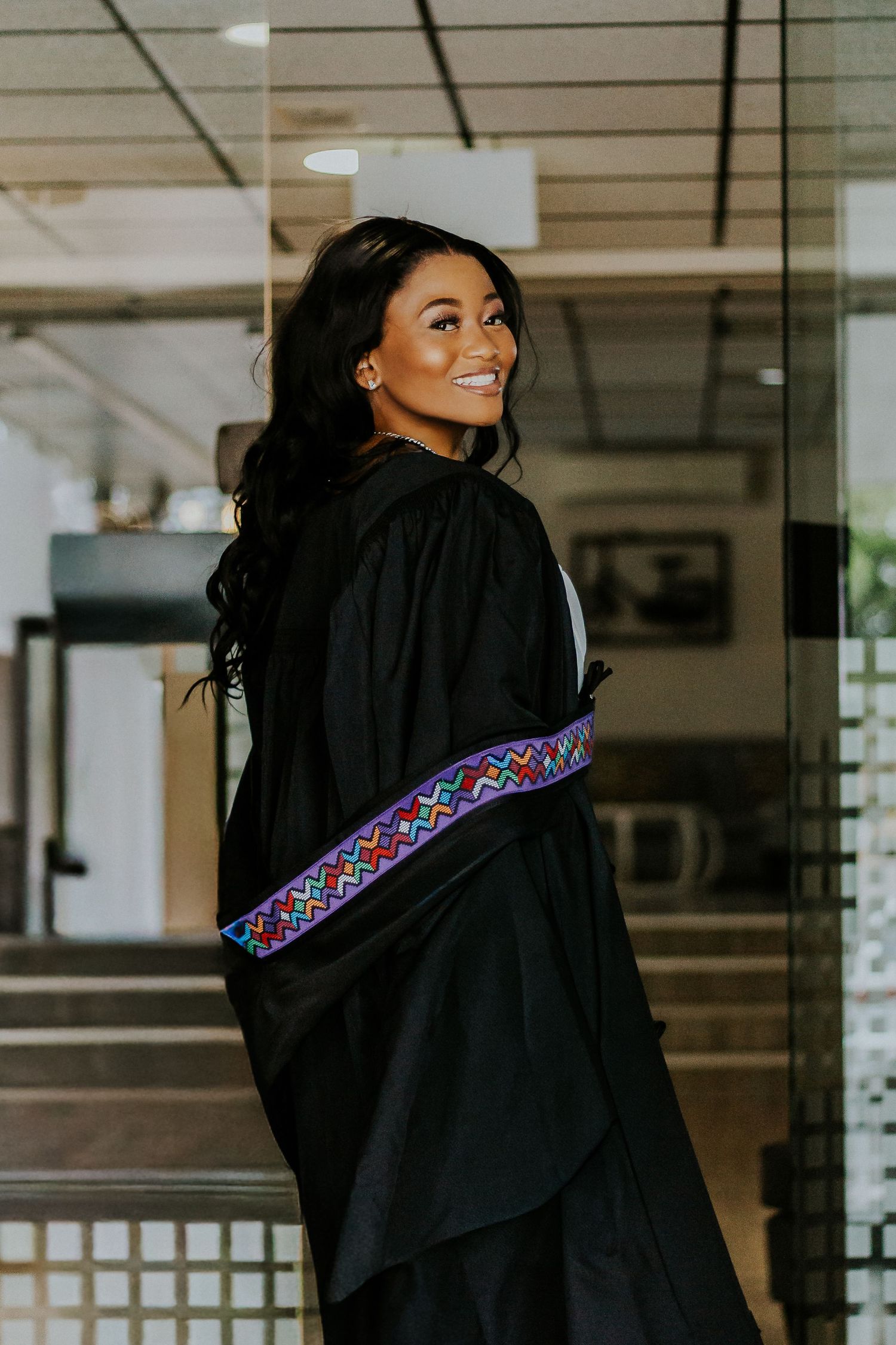Professional graduation portrait of a proud graduate in cap and gown, captured in natural light, celebrating academic success.