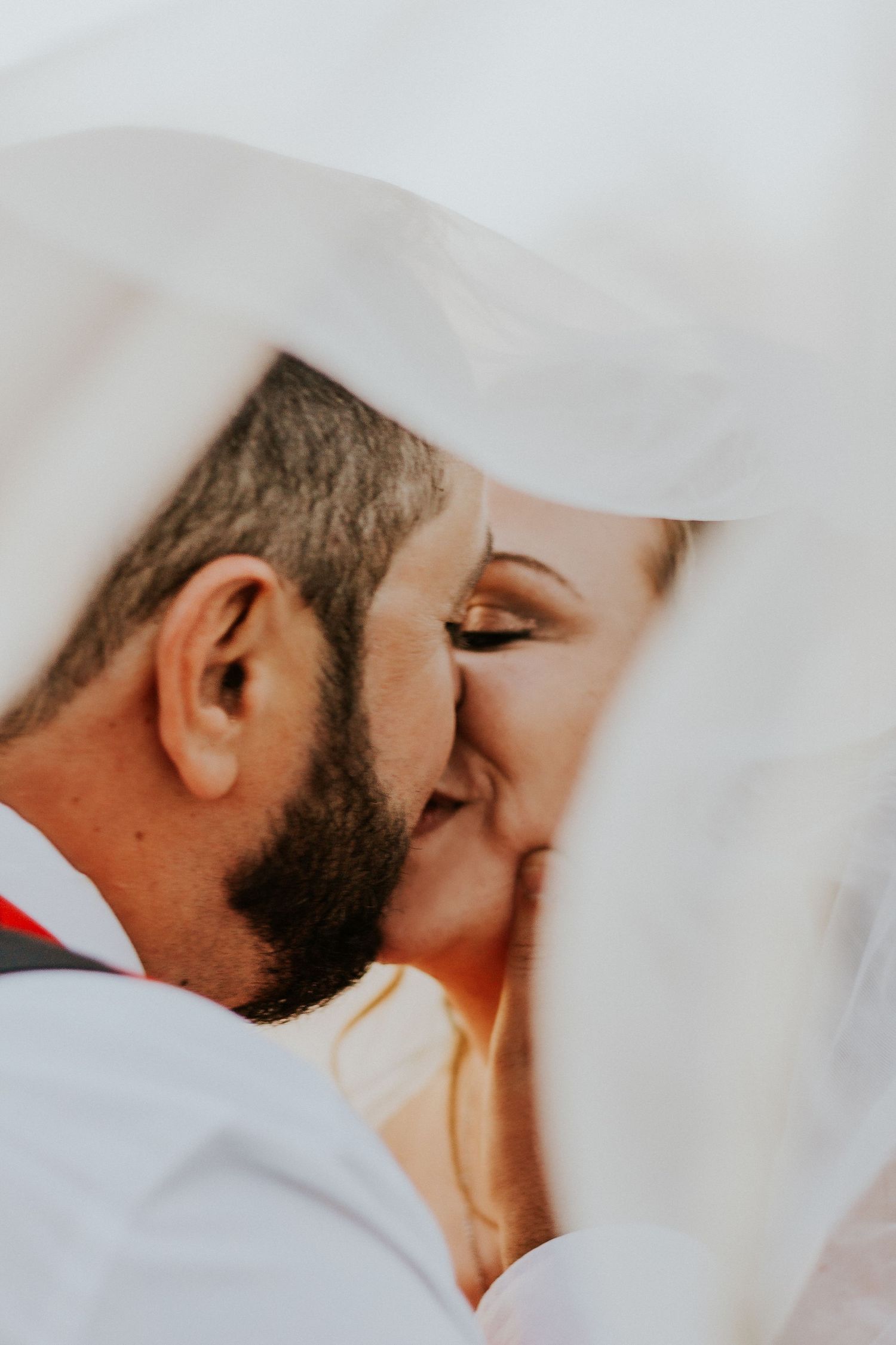 Emotional wedding portrait of a bride and groom sharing a close laugh.