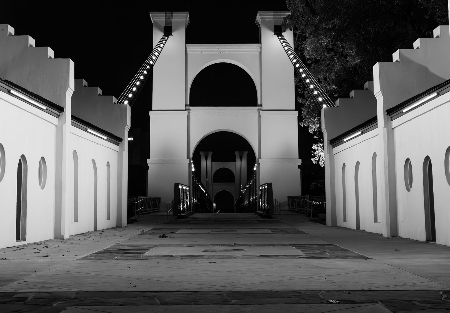 Black and white architectural photograph of repeating arches and columns.