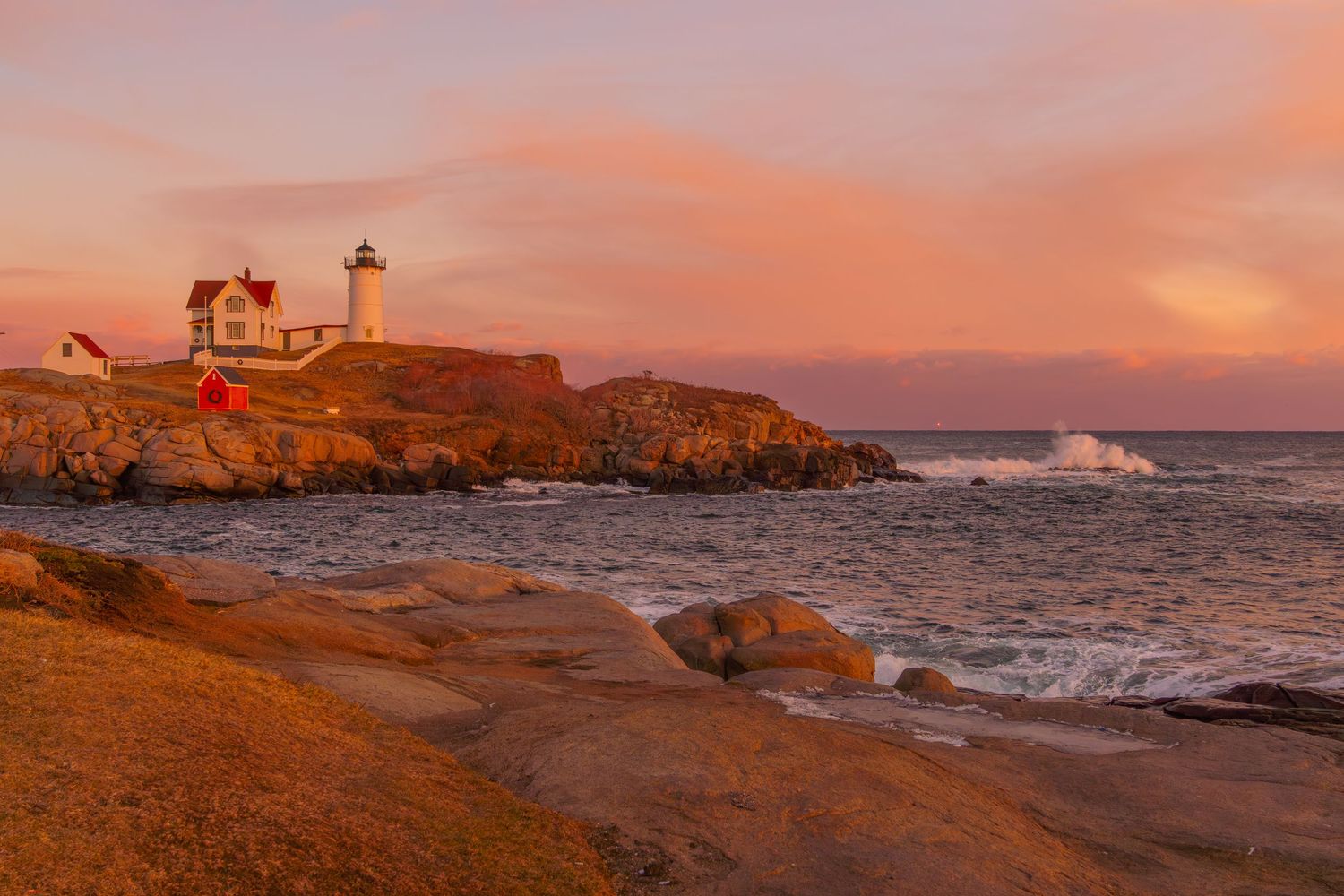 Nubble lighthouse during a beautiful pink sunset.