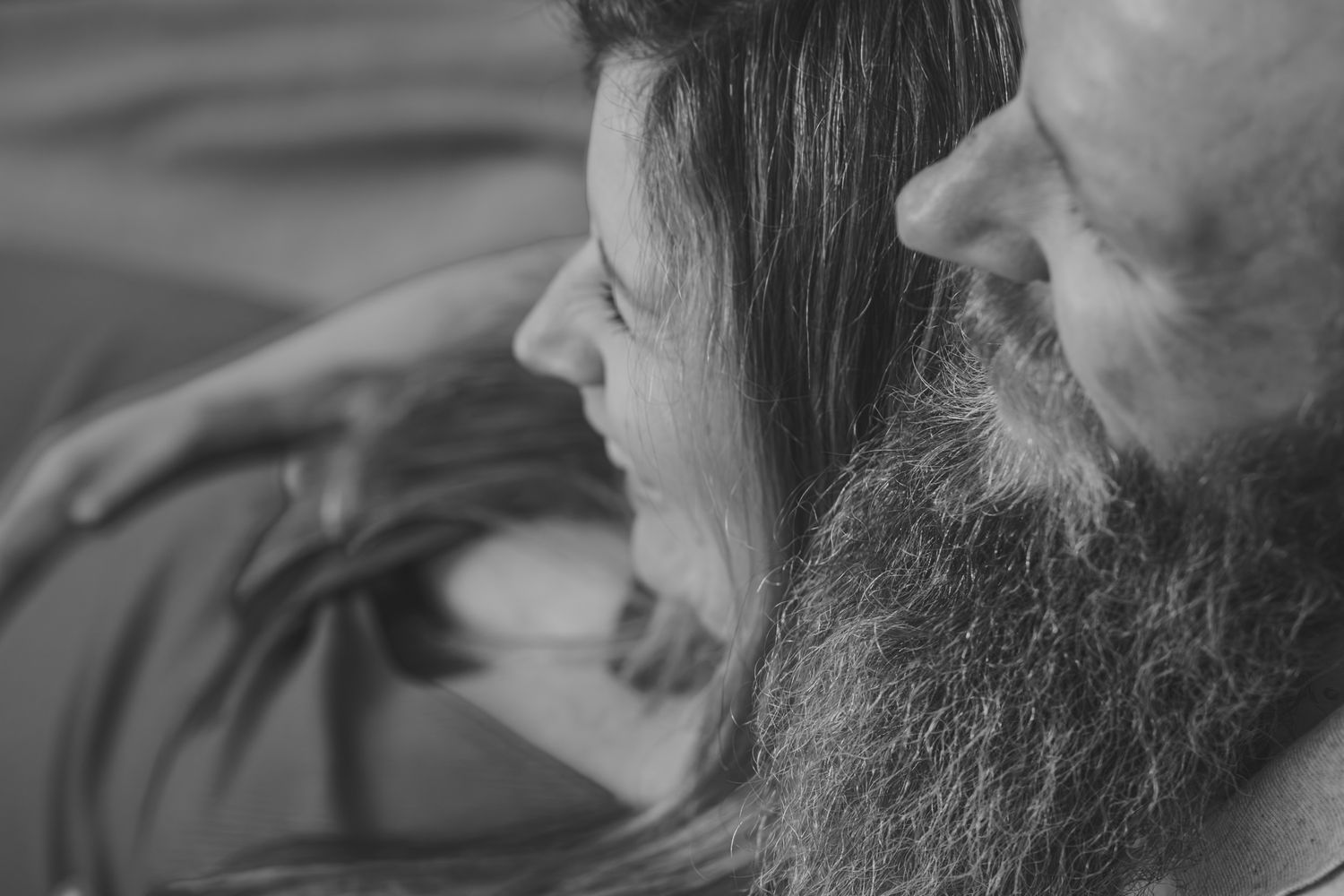 Close-up portrait showing intimate connection between two people outdoors.
