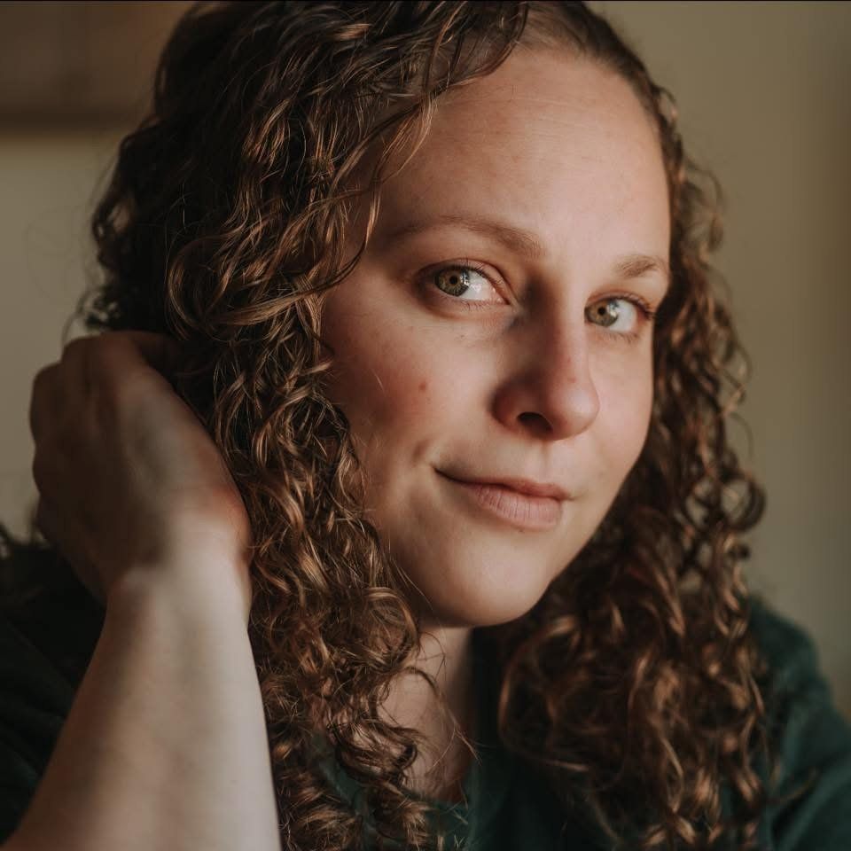 Artistic close-up portrait with dramatic indoor lighting and natural curls.