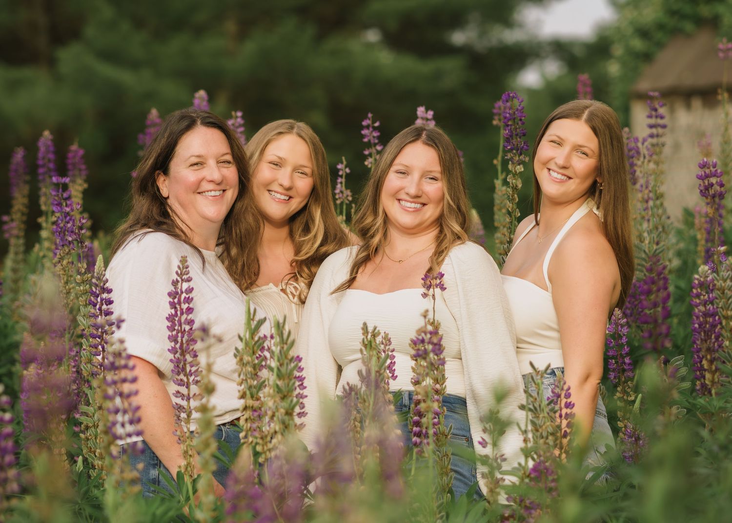 Friends gathered for portraits among flowering lupines in a lush garden setting.