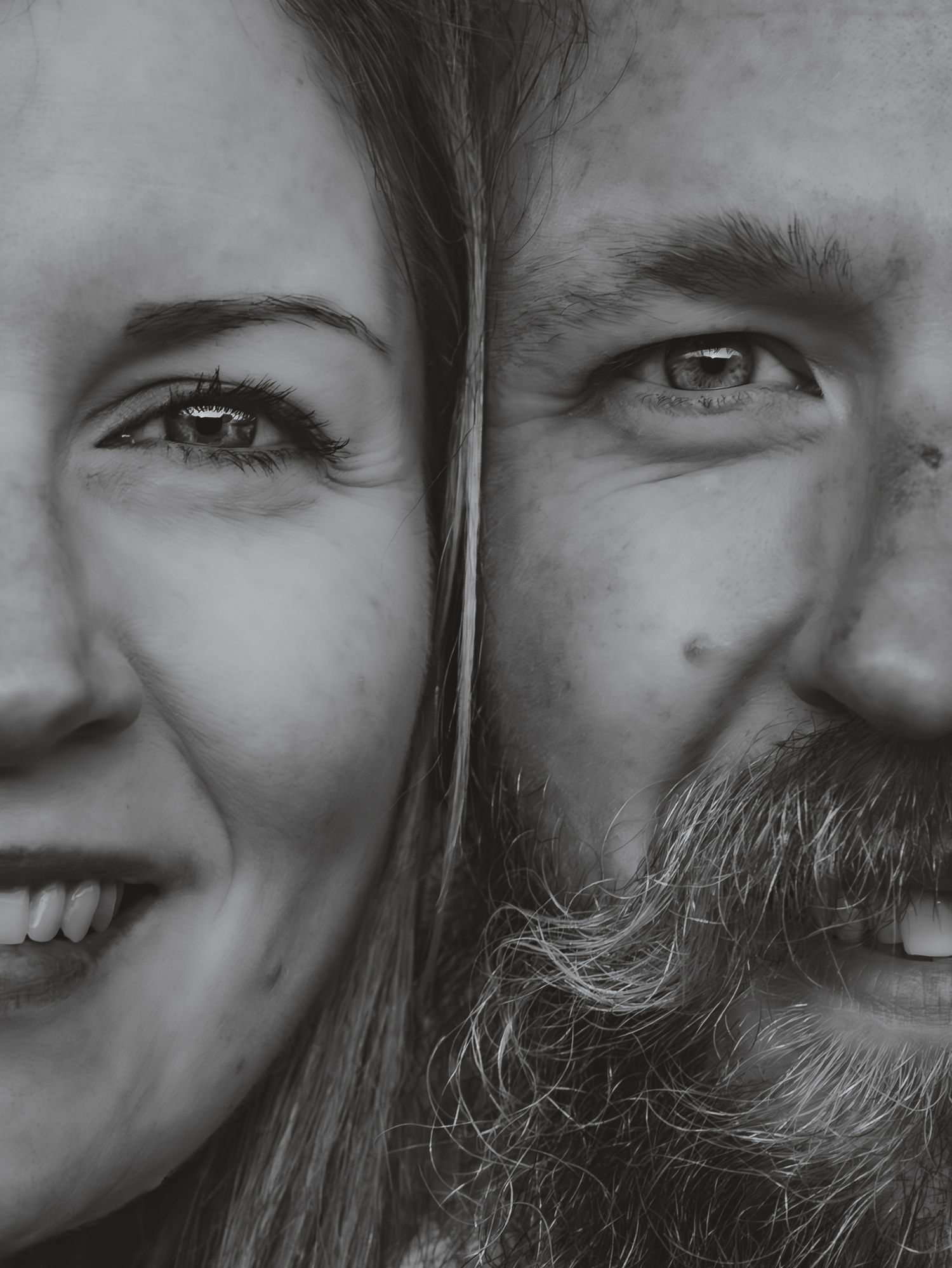 A black and white close-up photo showing two people's faces partially visible and smiling together.