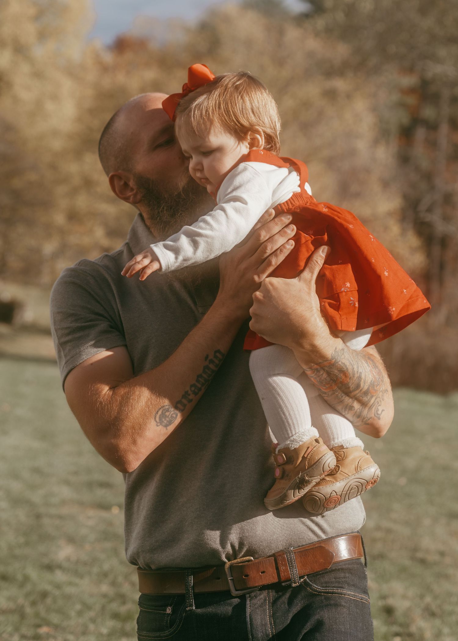 A tender moment captured outdoors showing affection and playfulness in warm autumn light.