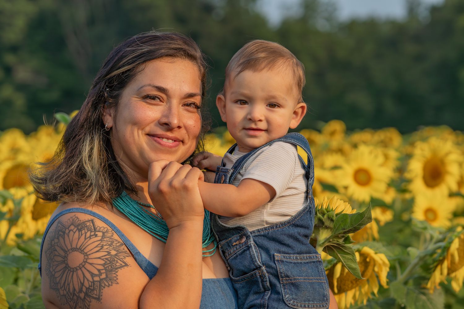 A beautiful sunflower field serves as backdrop for outdoor family portraits at golden hour.