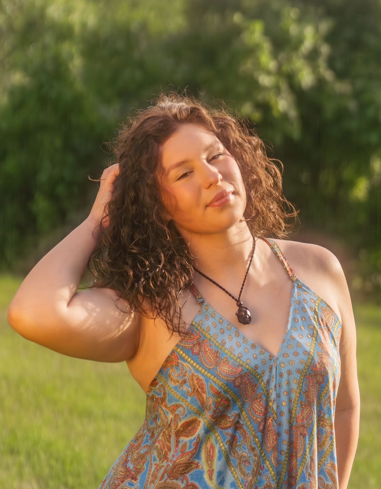 A summer portrait session in a sunlit field with flowing hair movement.