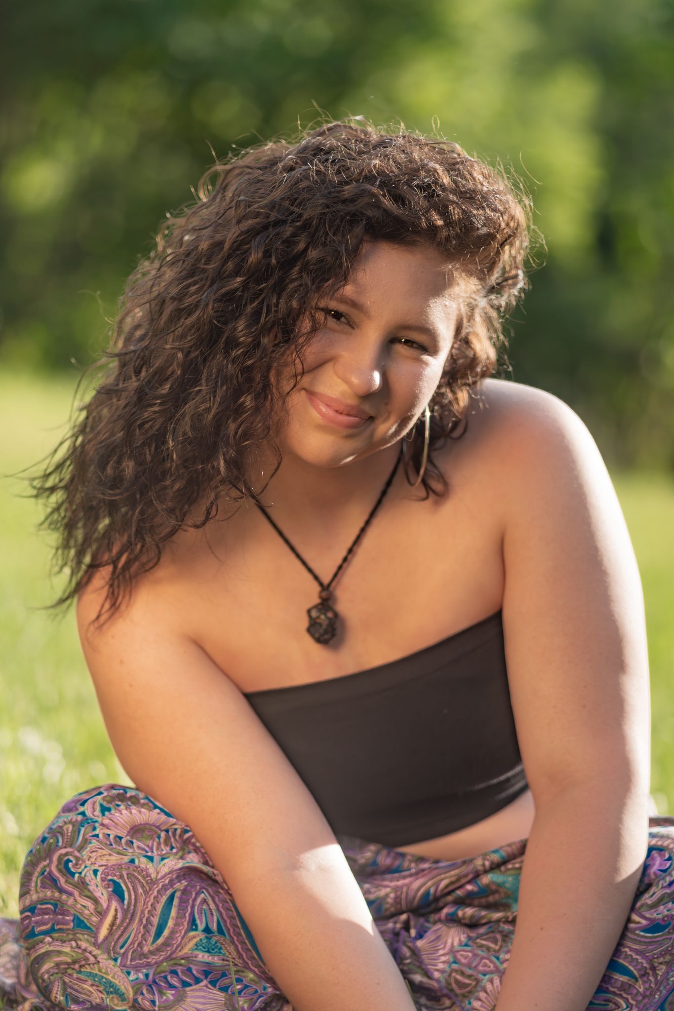Outdoor portrait series featuring curly hair and patterned clothing in natural lighting.