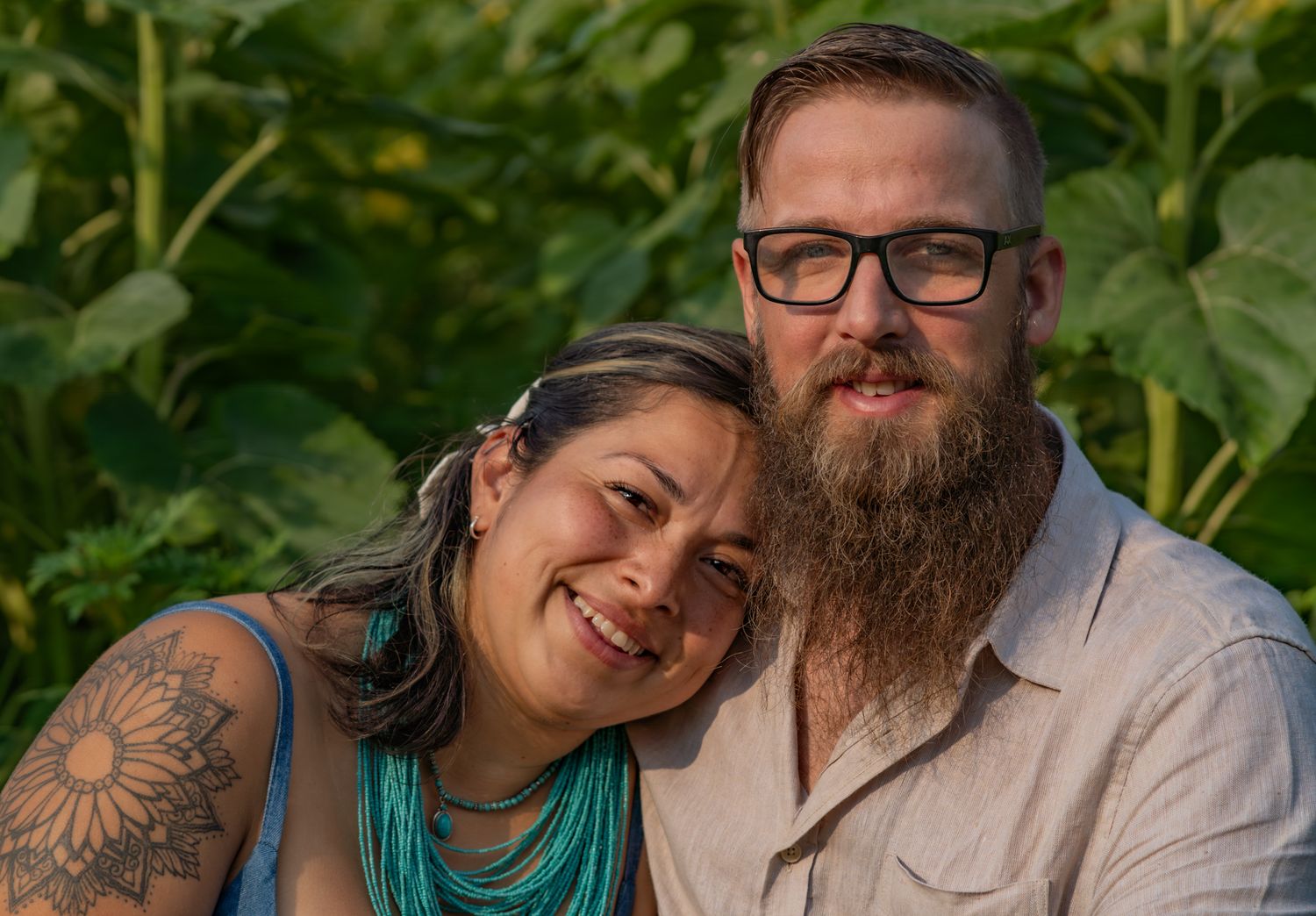 A couple shares intimate moments in a lush sunflower field.