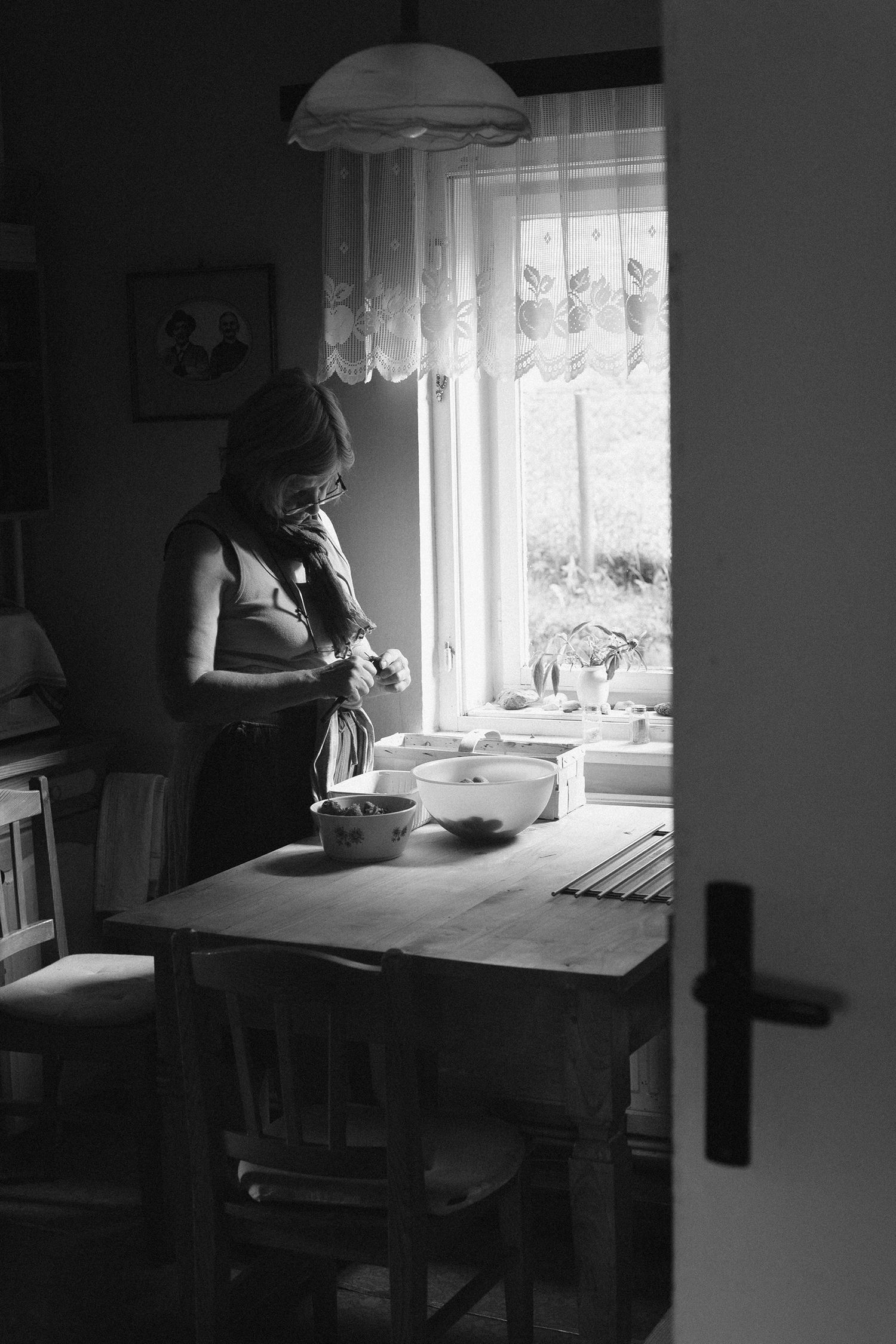 Black and white photo series showing someone working at a table near a window with natural light.