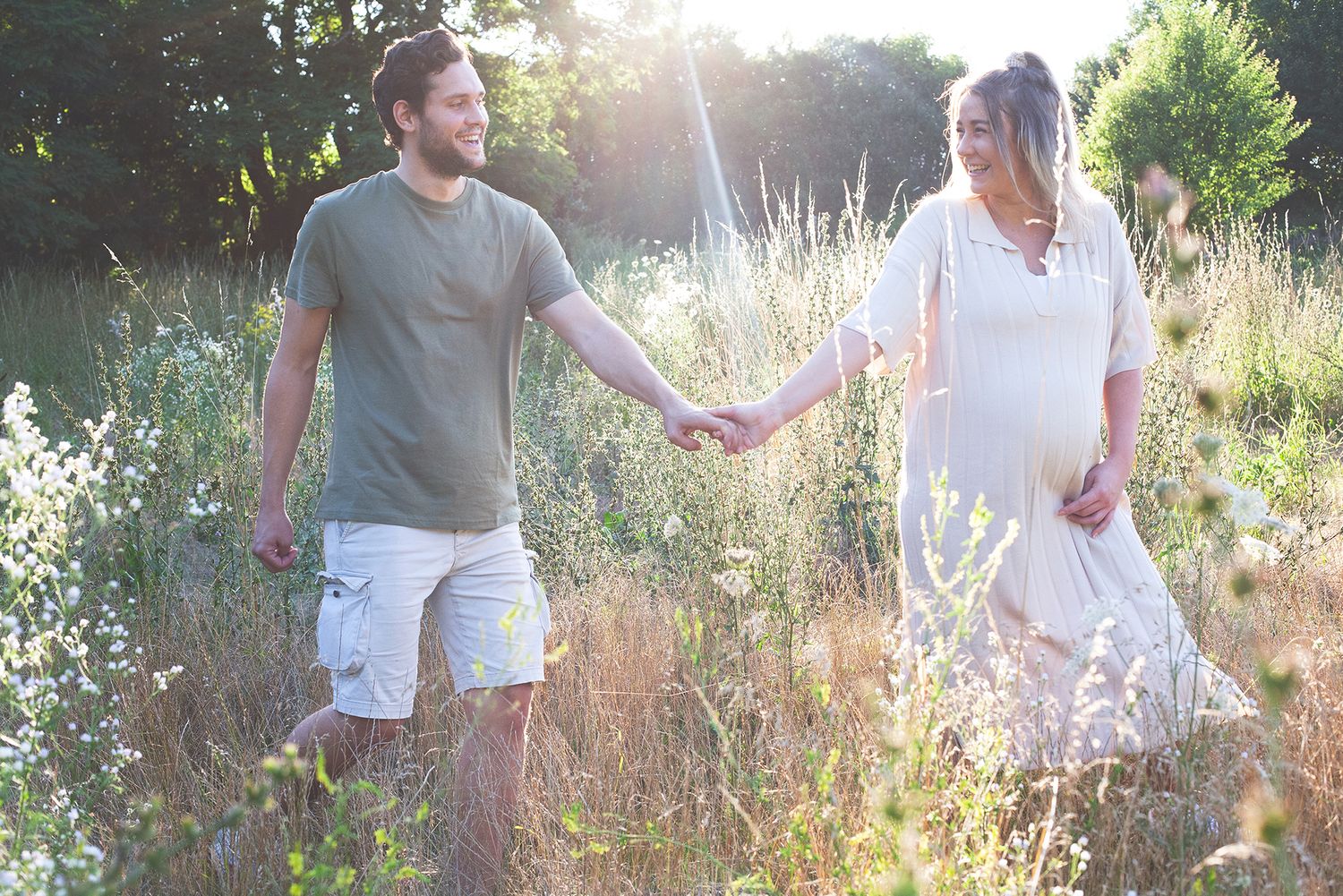 Couple standing together in a summer meadow during golden hour.