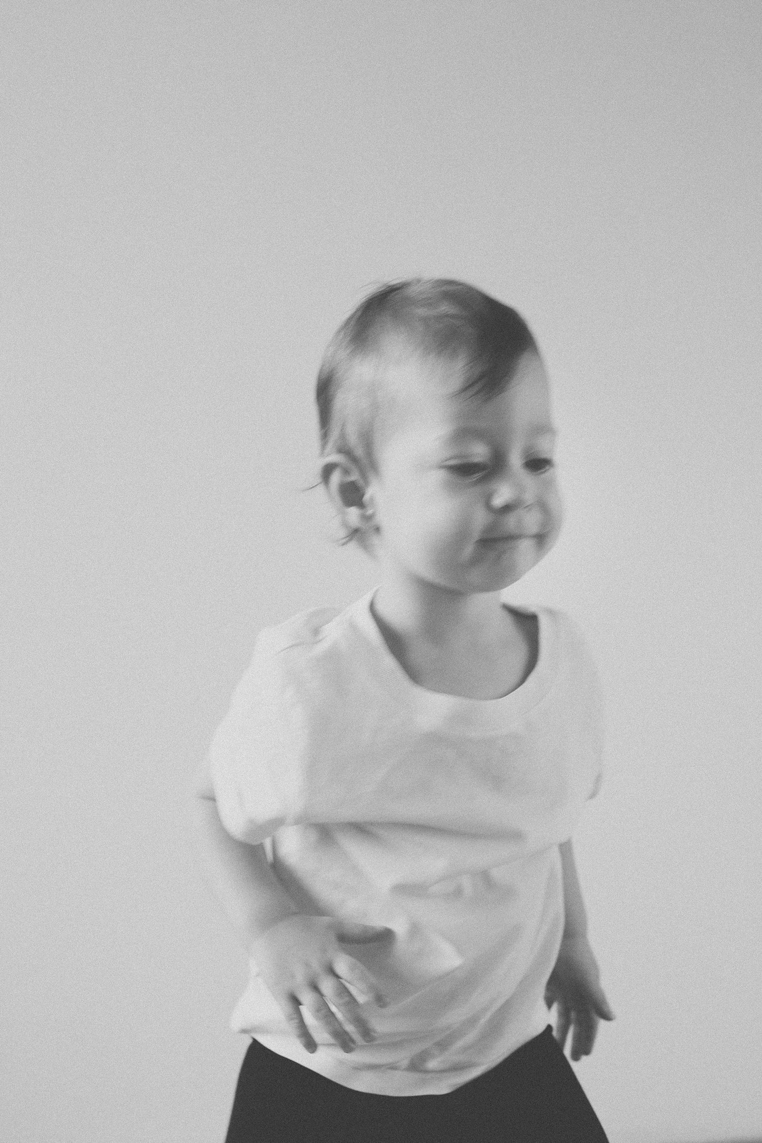 A series of motion blur photos showing a child in white shirt moving and playing.