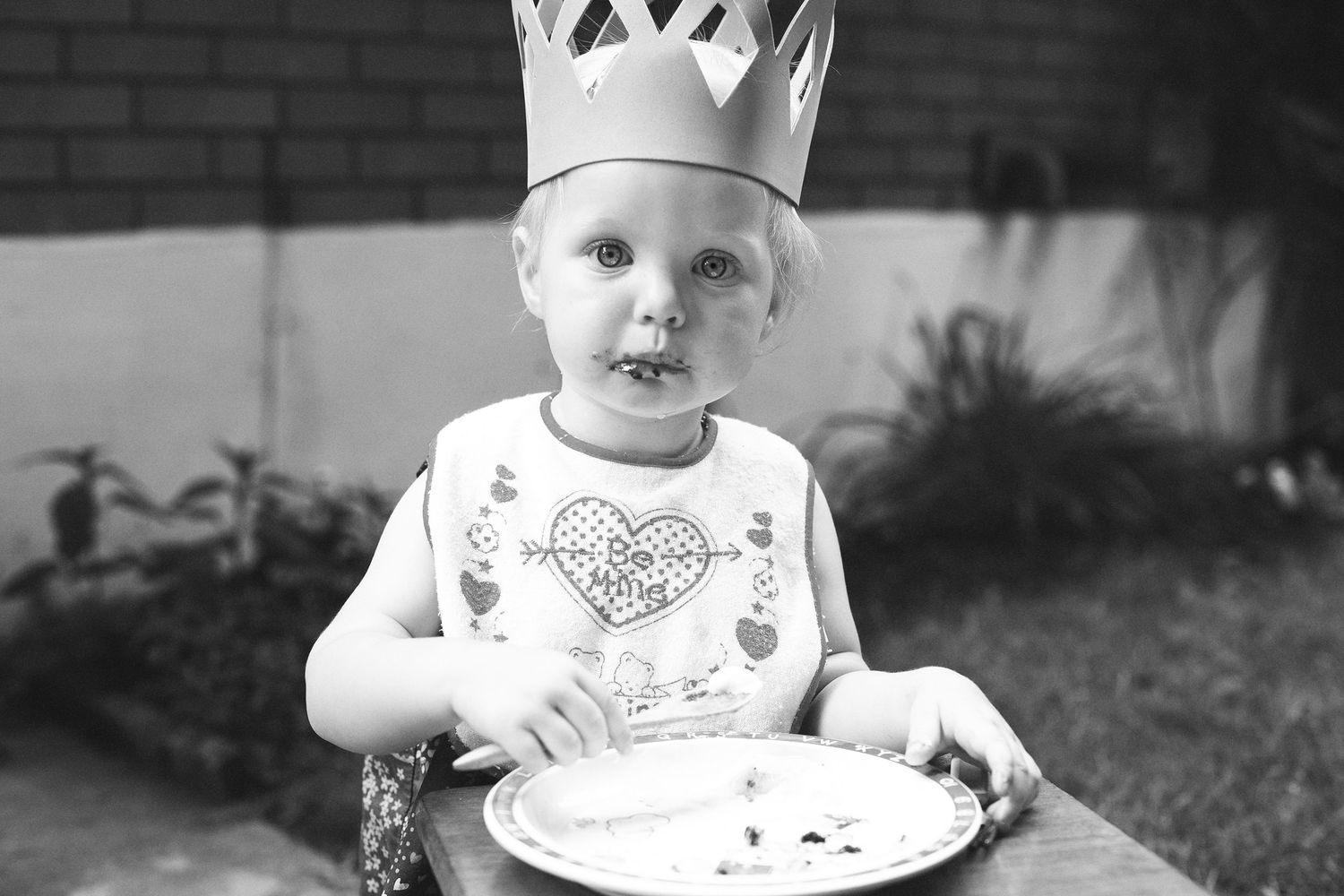 Series of black and white photographs showing a small child in a high chair.