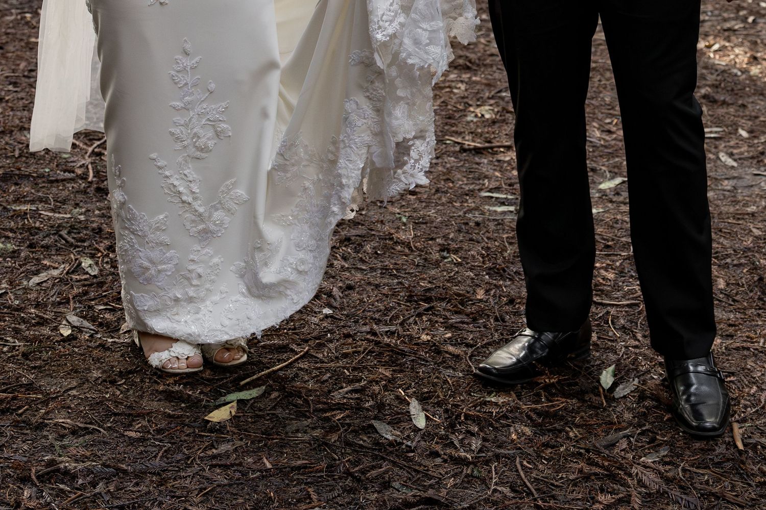 Close-up of elopement couple standing on pine needle covered ground by Taylor Zimmerman Photo