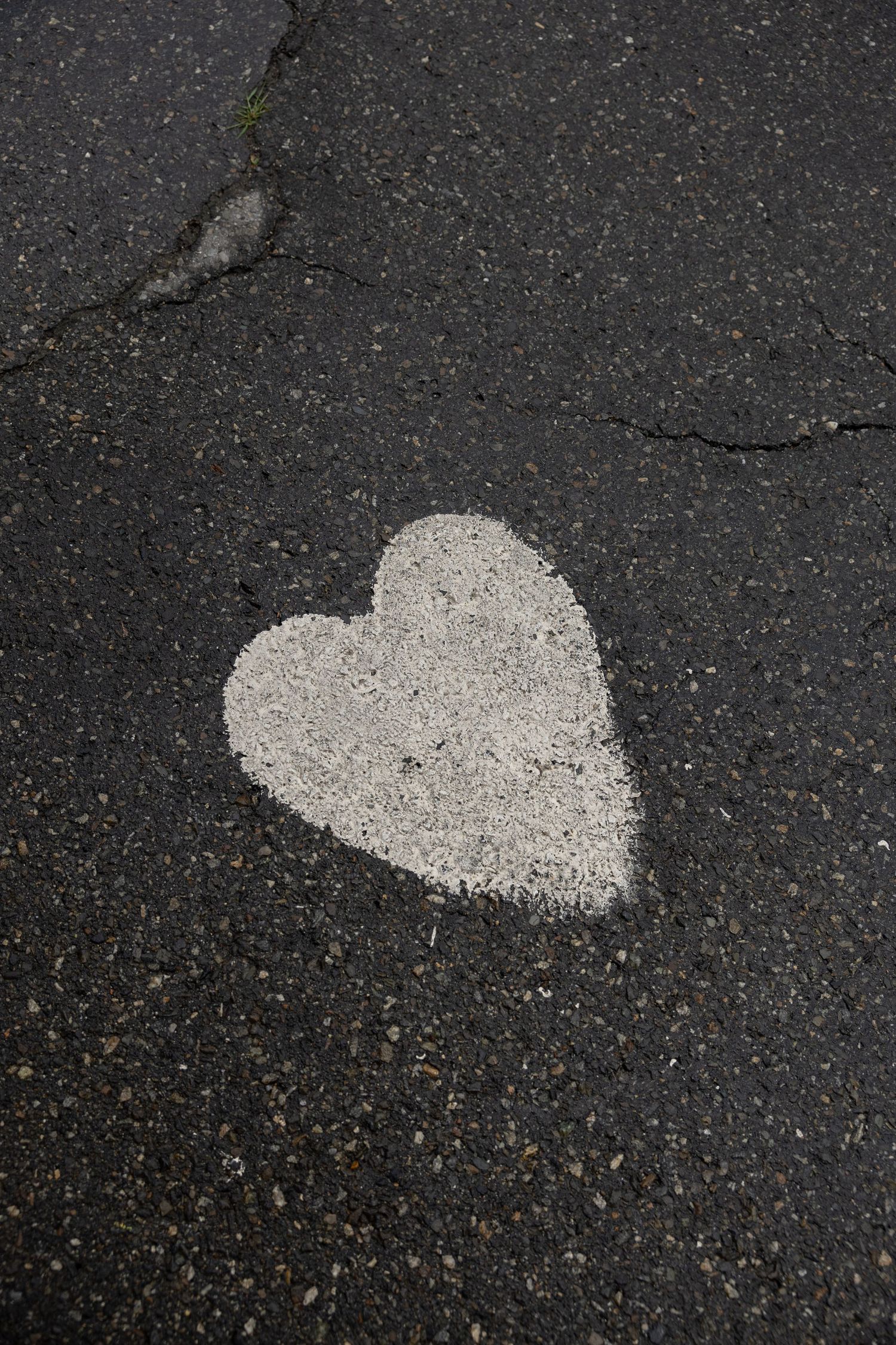 A white heart painted on a rainy sidewalk by Taylor Zimmerman Photo